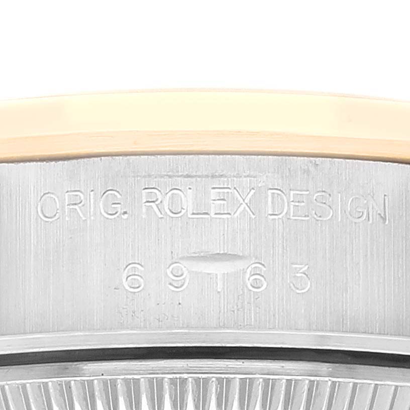 This close-up image shows the side view of a Rolex Datejust 69163 Women's Steel and Gold (two tone) Silver Dial 69163 Women's Steel and Gold (two tone) Silver Dial watch, featuring the engravings on its case.