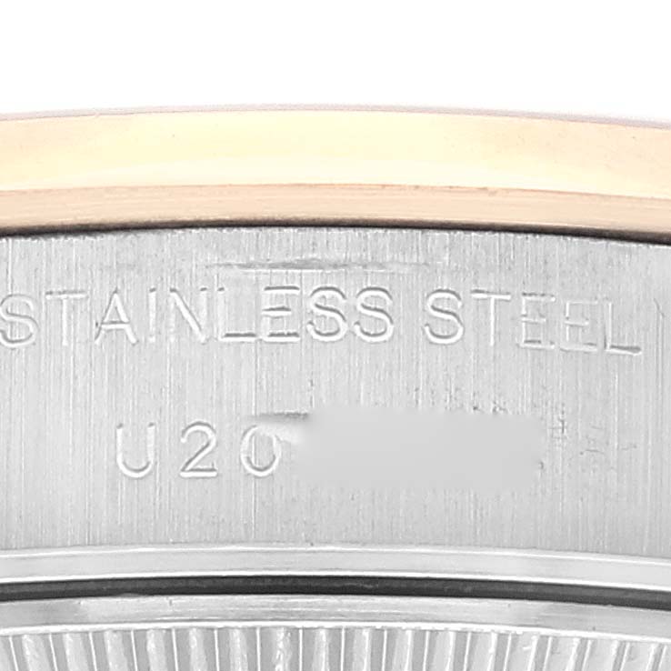 This zoomed-in image of a Rolex Datejust 69163 Women's Steel and Gold (two tone) Silver Dial 69163 Women's Steel and Gold (two tone) Silver Dial watch shows the stainless steel case with engraved text and a partial view of the bezel.