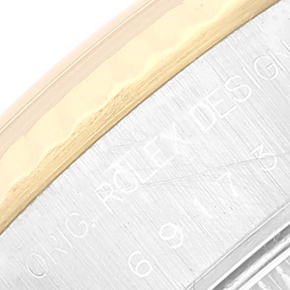 This image shows a close-up of the edge of a Rolex Datejust 69173 Women's Steel and Gold (two tone) Beige Dial 69173 Women's Steel and Gold (two tone) Beige Dial model, featuring part of the gold and silver bezel with engraving.