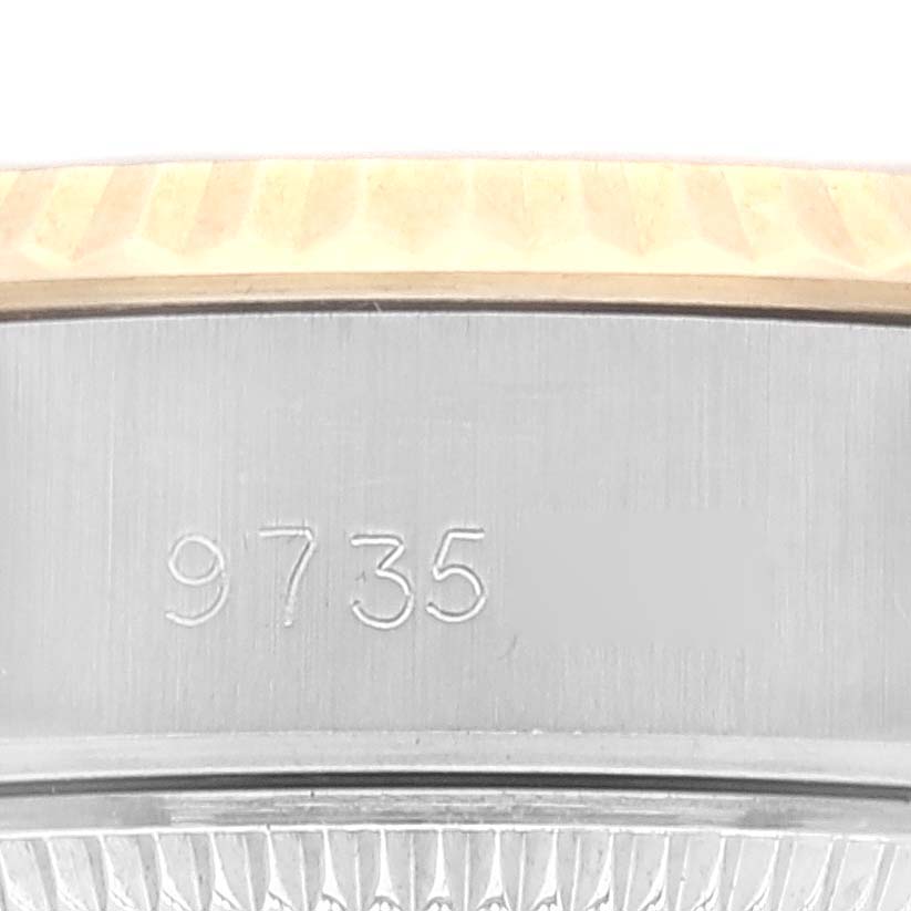 This close-up shows the side of the Rolex Datejust 69173 Women's Steel and Gold (two tone) White Dial 69173 Women's Steel and Gold (two tone) White Dial watch, highlighting the engraved serial number and part of the fluted bezel.