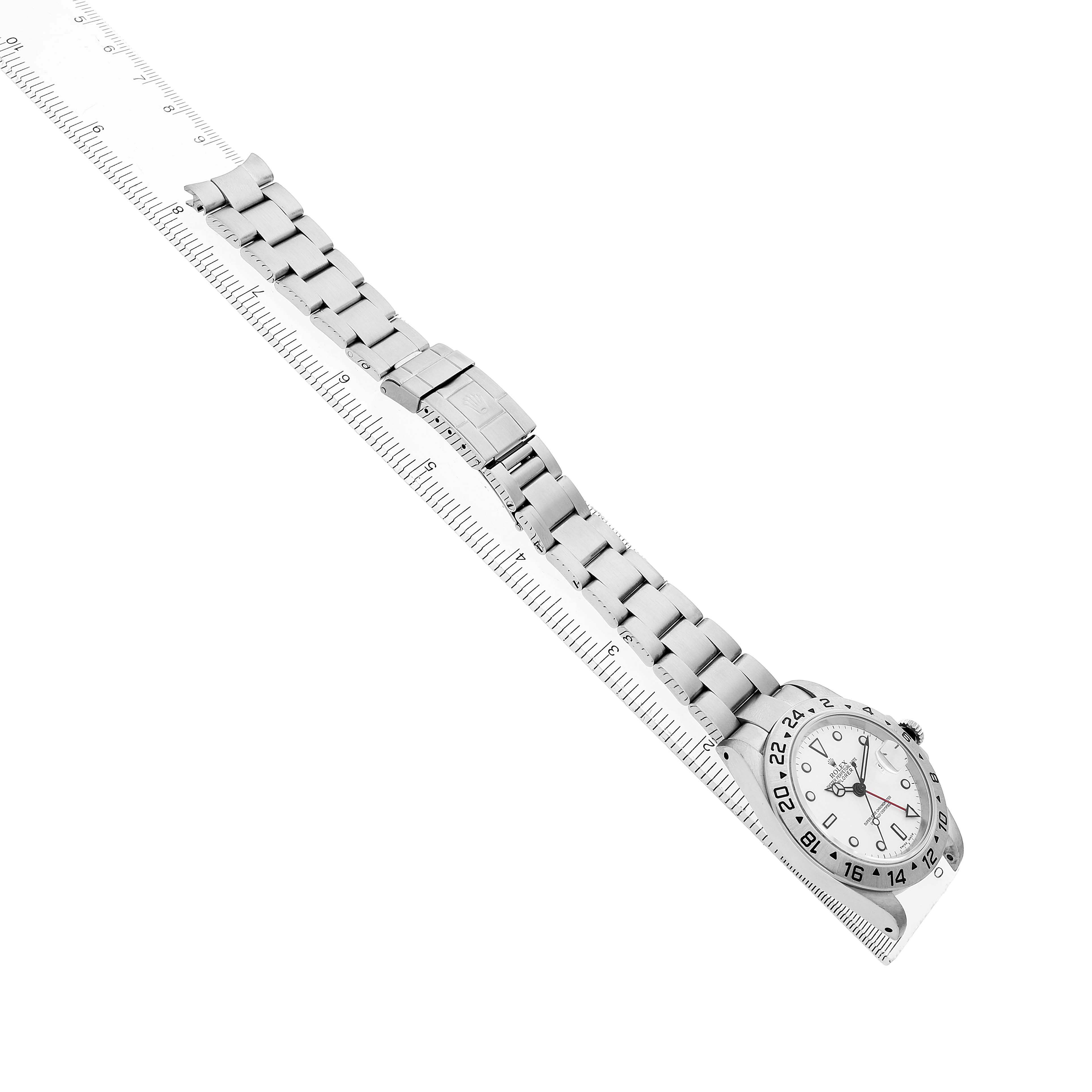 The image shows a Rolex Explorer 16570 Men's Stainless Steel White Dial watch from an angled side view, highlighting its face, bracelet, and clasp alongside a ruler.