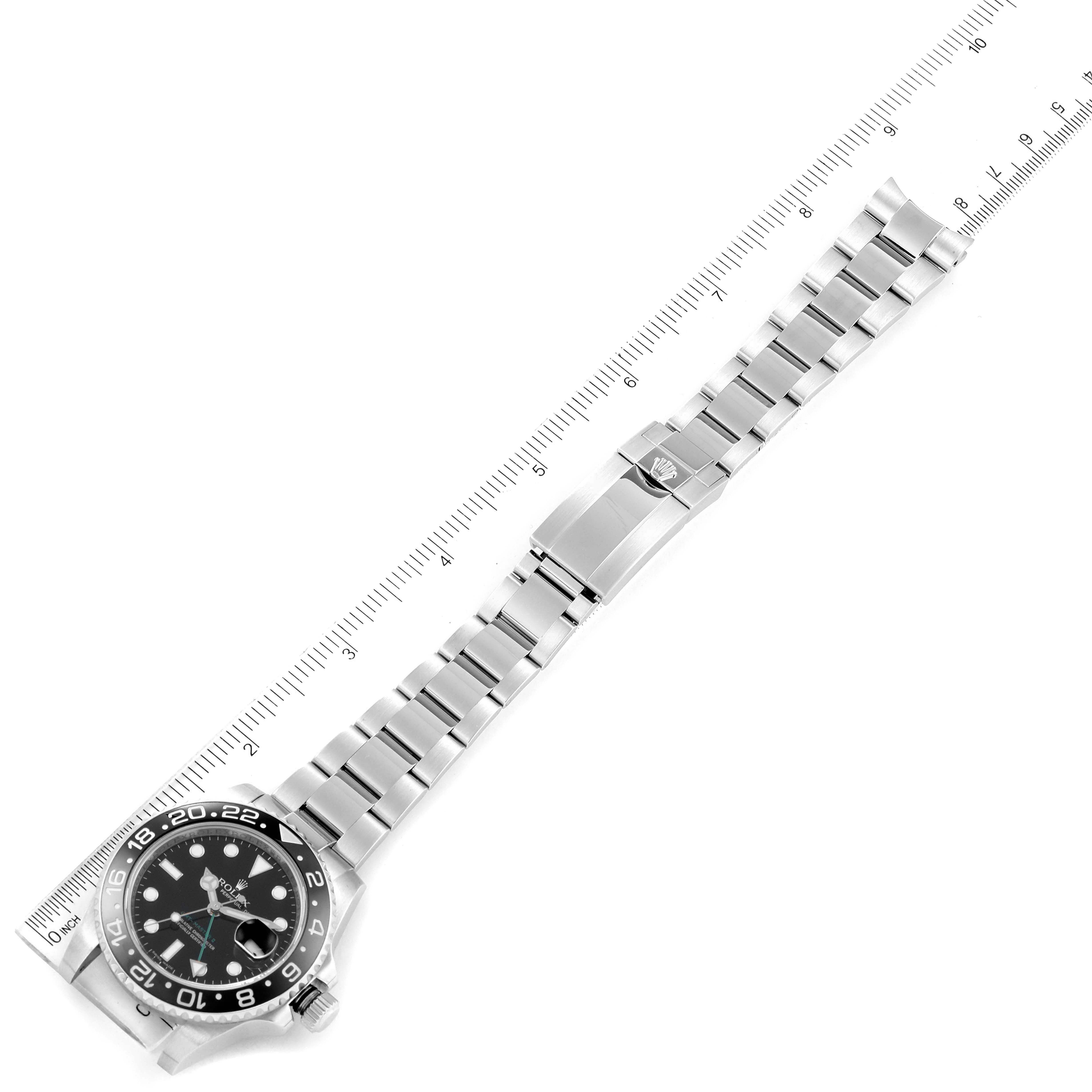 The image shows a top-down view of a Rolex GMT-Master 116710 Men
s Stainless Steel Black Dial 116710 Men
s Stainless Steel Black Dial watch, highlighting the face, bezel, and bracelet with a measuring ruler included.