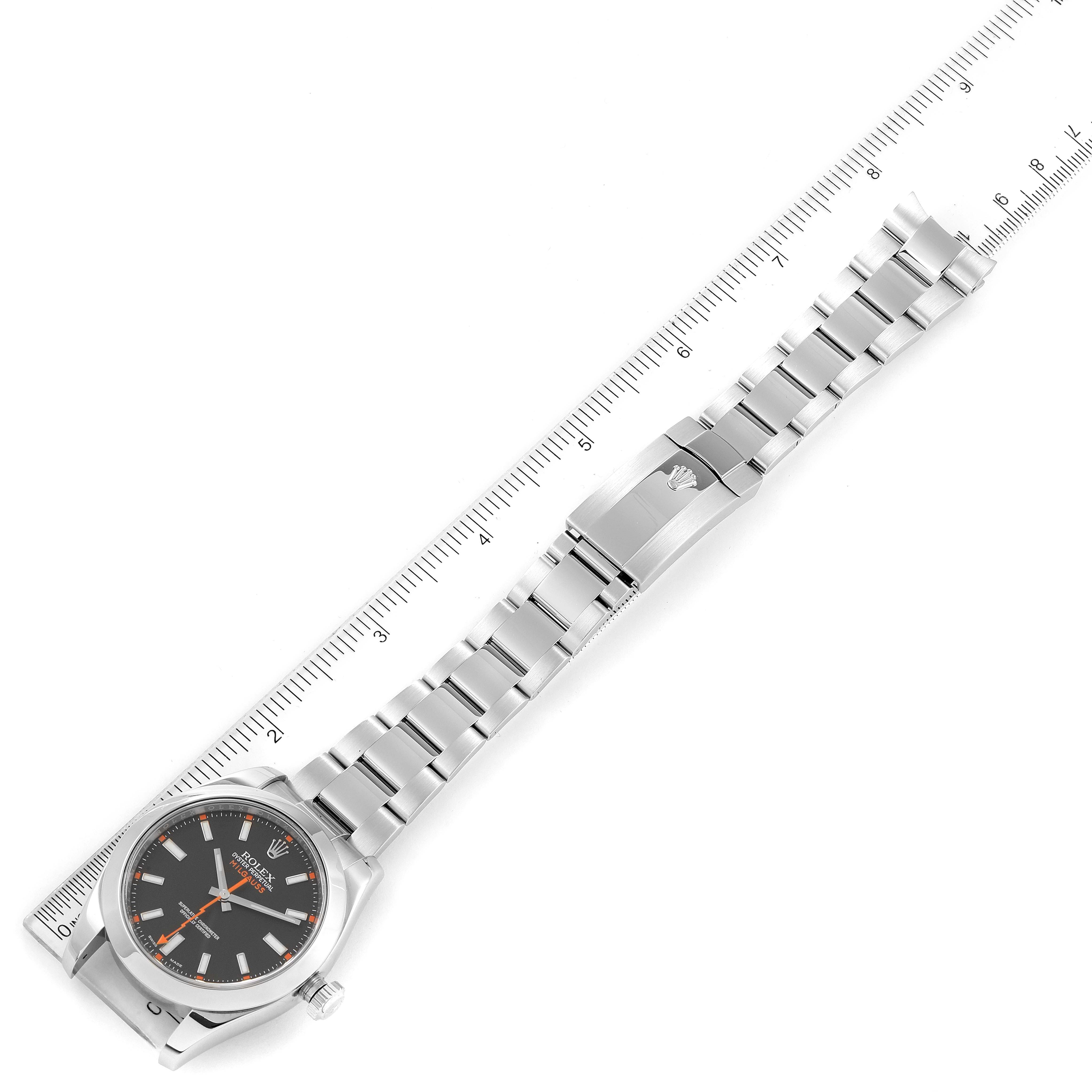 This image shows a Rolex Milgauss 116400 Men's Stainless Steel Black Dial 116400 Men's Stainless Steel Black Dial watch laid flat against a ruler, displaying its face, bracelet, and clasp.