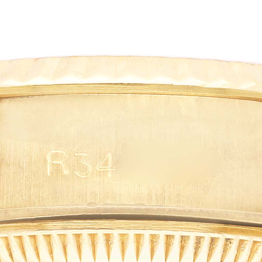 The image shows a close-up of the side of a Rolex President 69178 Women's Yellow Gold White Dial 69178 Women's Yellow Gold White Dial model watch, focusing on its case with engraved details.