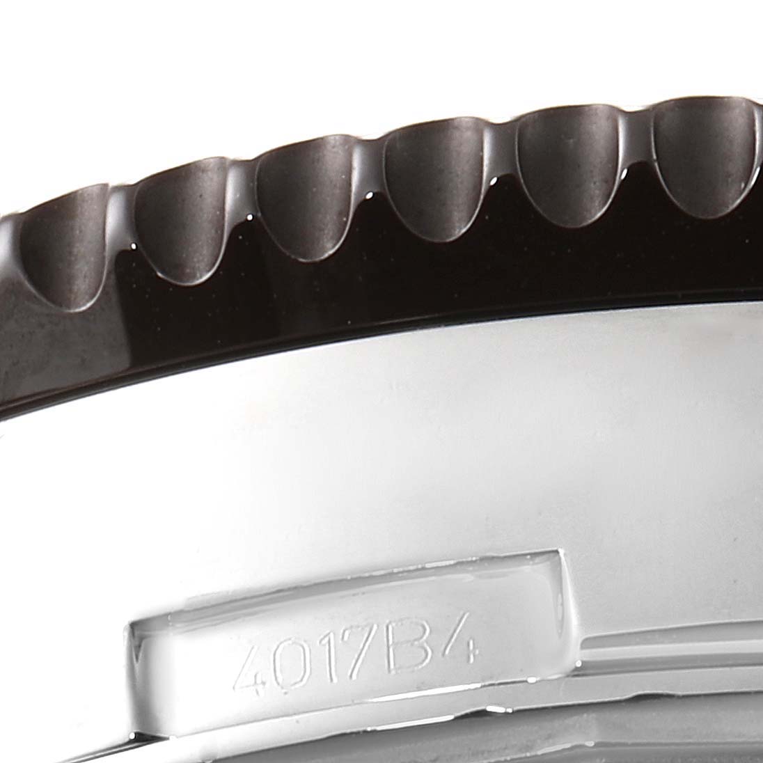 This close-up image of the Breitling Chronoliner Y24310 Men's Stainless Steel Brown Dial Y24310 Men's Stainless Steel Brown Dial watch shows a segment of the bezel and a part of the engraved caseback.