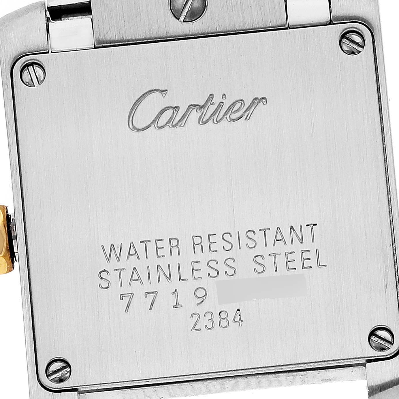 The image shows the back case of a Cartier Tank Française watch, displaying its engravings and screws.