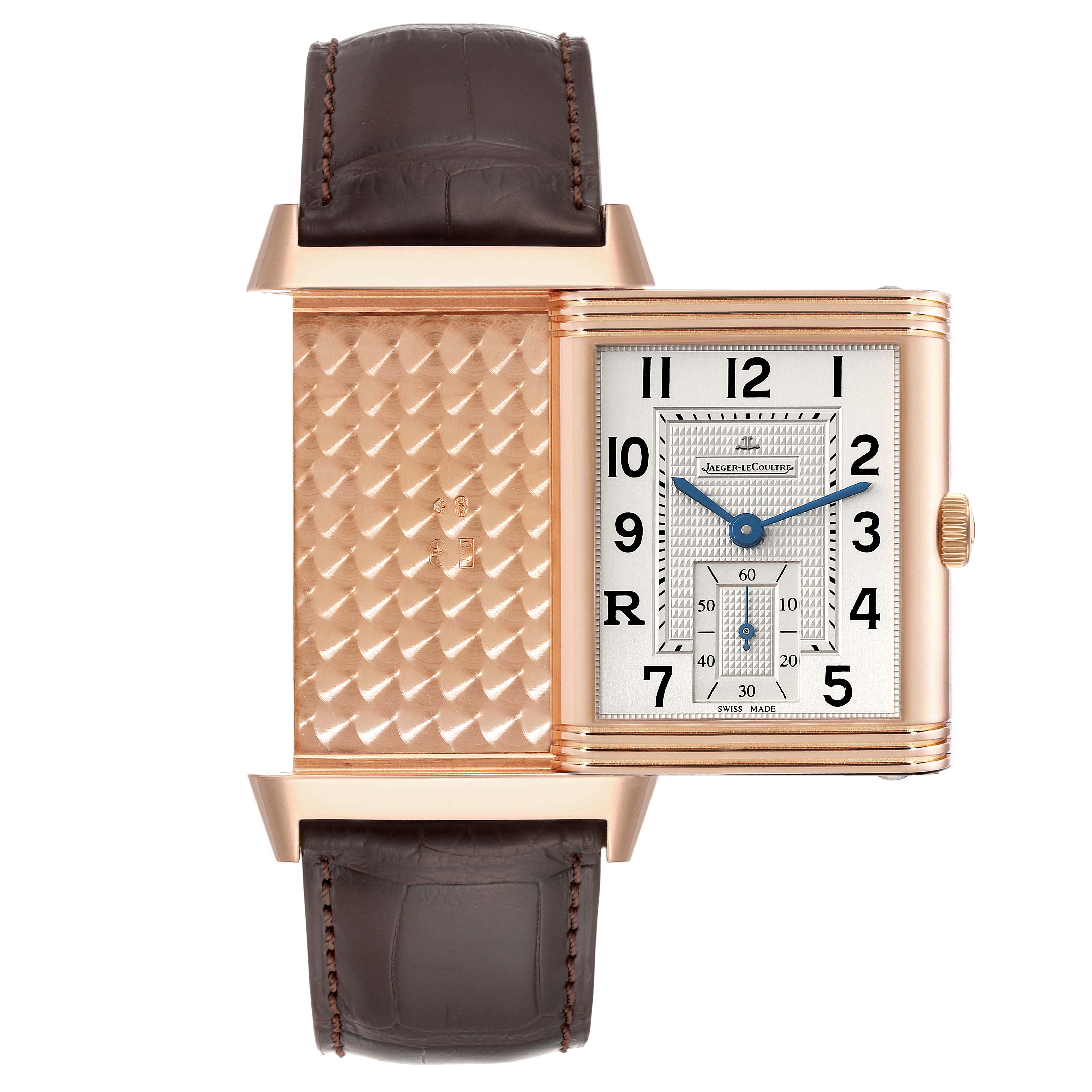 The image shows a front view of the Jaeger LeCoultre Reverso Q3732420 Men's Rose Gold Silver Dial Q3732420 Men's Rose Gold Silver Dial watch with its case partially rotated to display both the dial and the intricately engraved case back.
