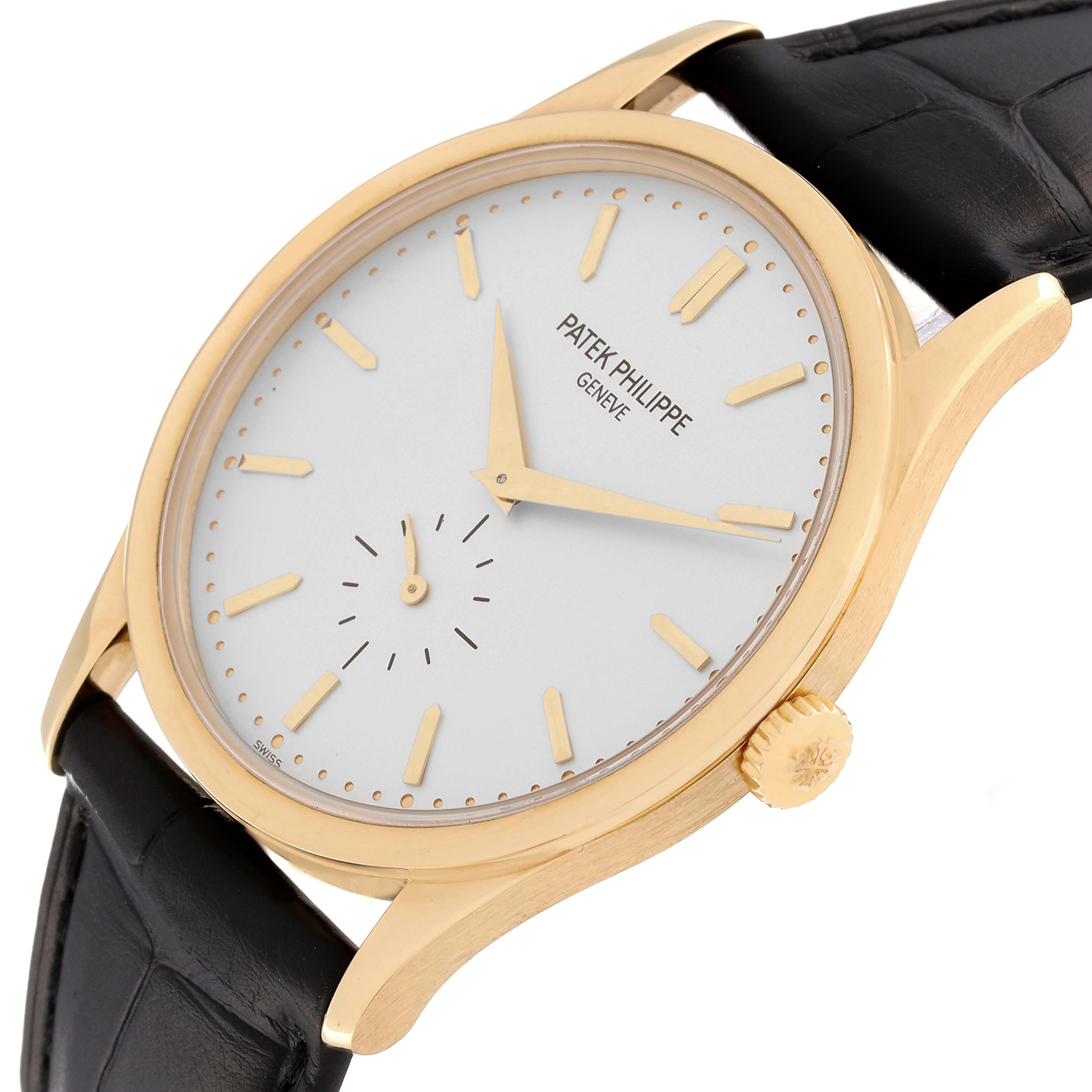 The image shows a Patek Philippe Calatrava 5196J Men's Yellow Gold Silver Dial 5196J Men's Yellow Gold Silver Dial watch at an angled side view, highlighting the dial, case, crown, and part of the strap.