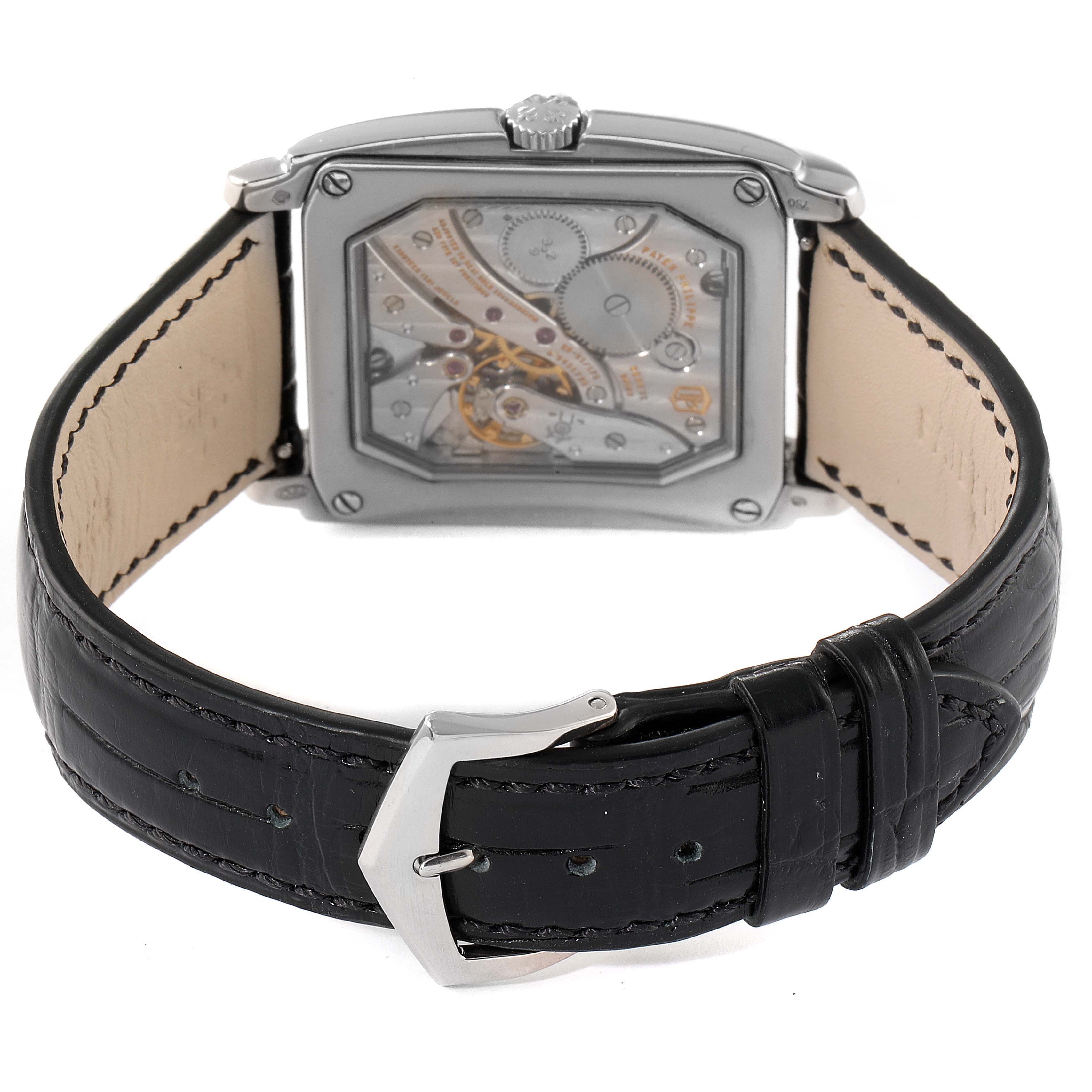 The image shows the back view of a Patek Philippe Gondolo 5124G Men's White Gold Champagne Dial 5124G Men's White Gold Champagne Dial watch featuring its movement and black leather strap with a silver buckle.