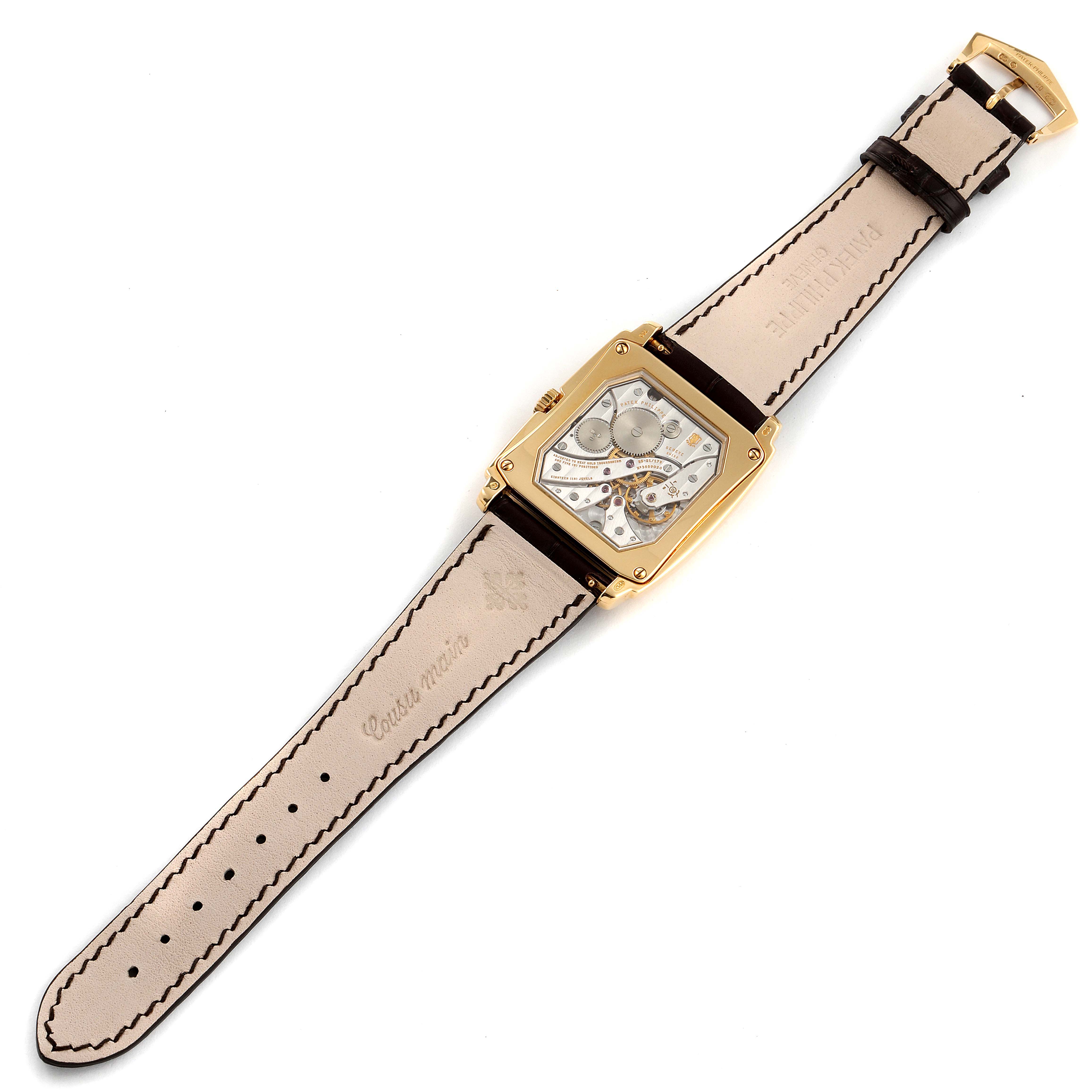 The image shows a Patek Philippe Gondolo 5124J Men's Yellow Gold Silver Dial 5124J Men's Yellow Gold Silver Dial watch from a top-down angle, highlighting its strap, case back, and movement.