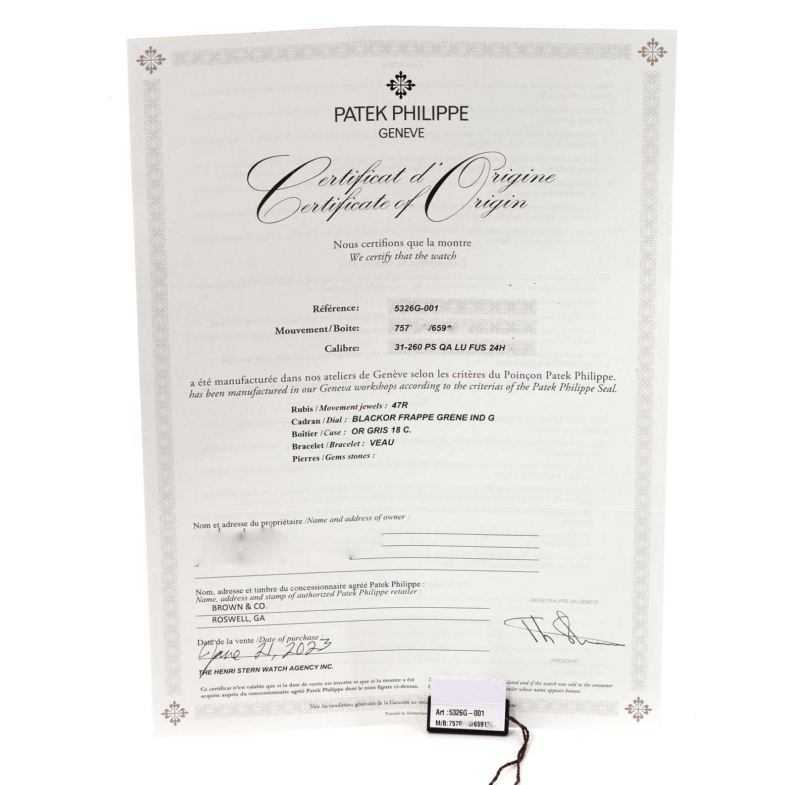 The image shows the Certificate of Origin and a tag for the Patek Philippe Complications 5326G-001 Men's White Gold Grey Dial 5326G-001 Men's White Gold Grey Dial model.