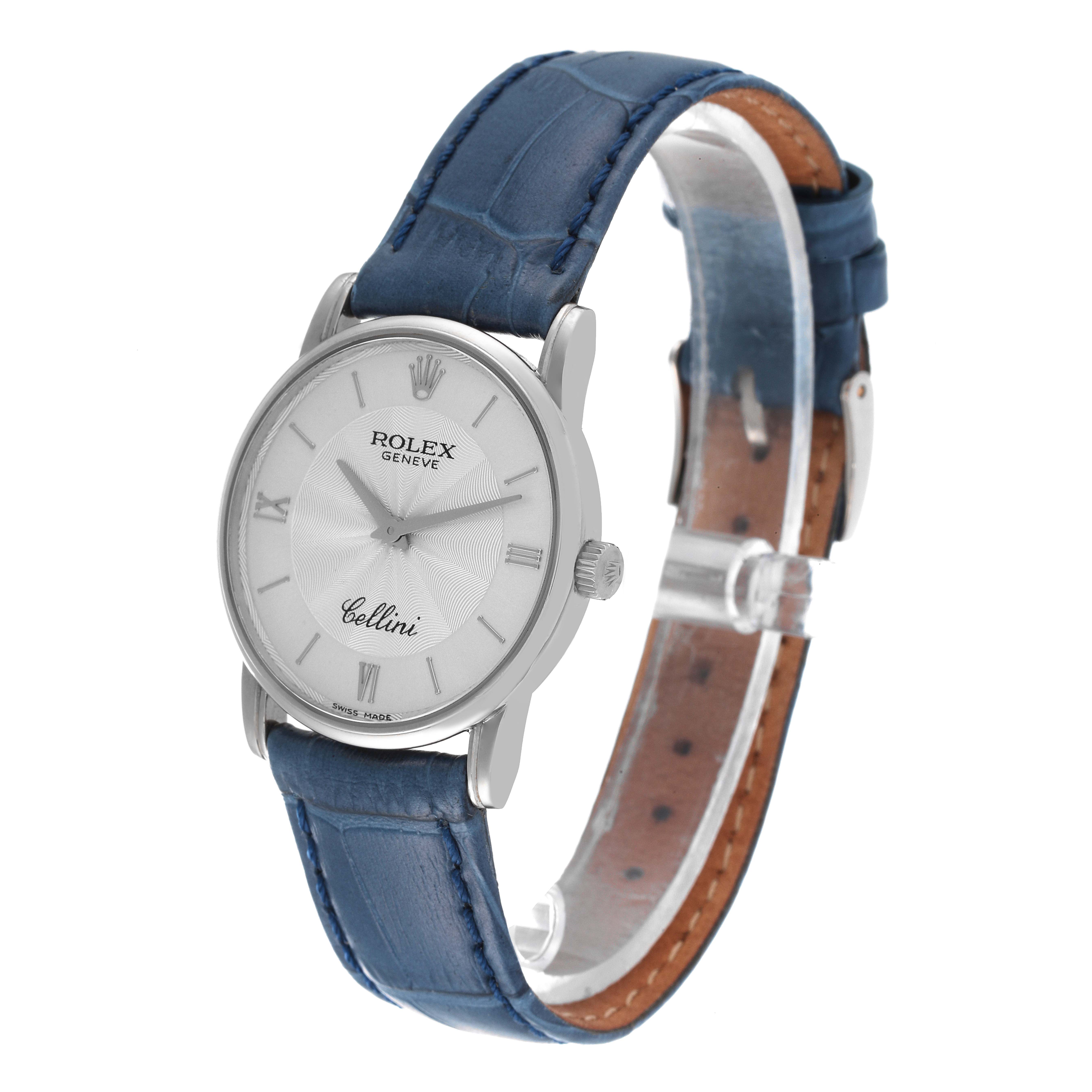The Rolex Cellini 5116 Men's White Gold Silver Dial 5116 Men's White Gold Silver Dial watch is shown at a front-angle view, displaying its face, crown, and blue leather strap.