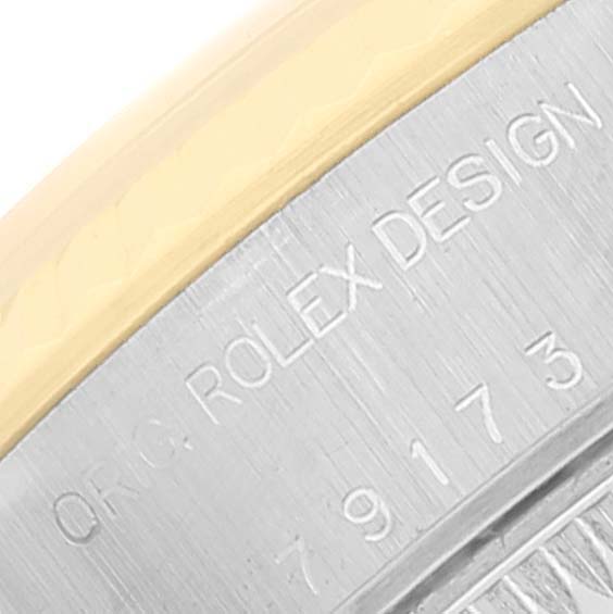 The image shows a close-up of the side engraving on the bezel of a Rolex Datejust 79173 Women's Steel and Gold (two tone) Beige Dial 79173 Women's Steel and Gold (two tone) Beige Dial watch.
