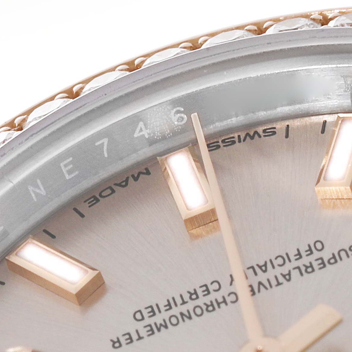 This close-up image of a Rolex Datejust 279381 Women's Steel and Gold (two tone) Pink Dial 279381 Women's Steel and Gold (two tone) Pink Dial watch shows part of the dial, bezel, and the hour markers.