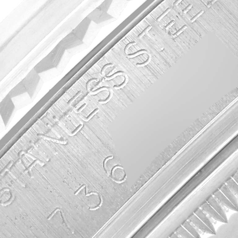 The image shows a close-up of the inner rim engraving on a Rolex Datejust 16014 Men
s Stainless Steel Silver Dial 16014 Men
s Stainless Steel Silver Dial watch, highlighting the text and stainless steel surface.
