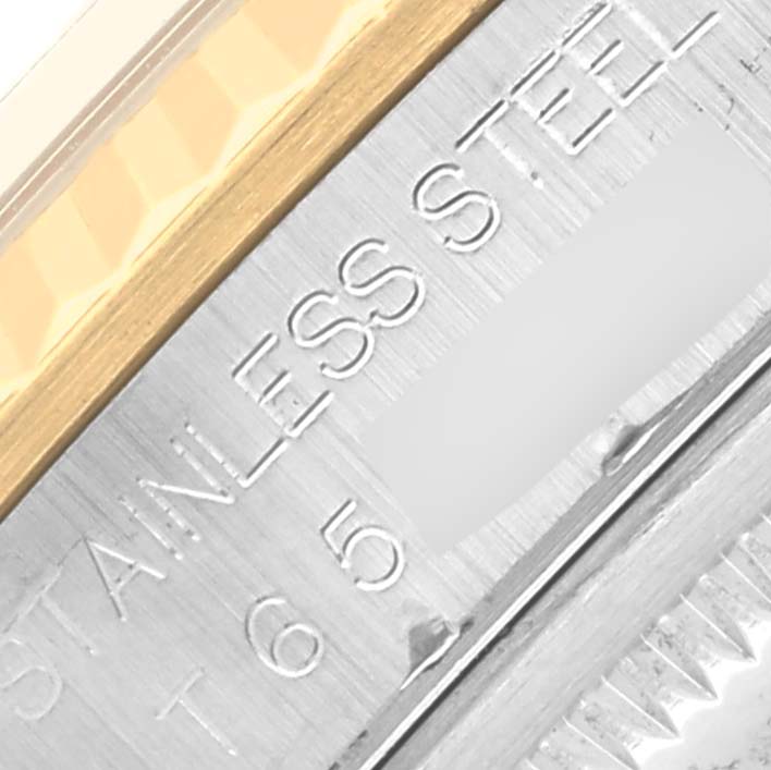 The image shows a close-up of a Rolex Datejust 16233 Men
s Steel and Gold (two tone) Black Dial 16233 Men
s Steel and Gold (two tone) Black Dial watch case, focusing on the stainless steel and gold detailing with engraved text.