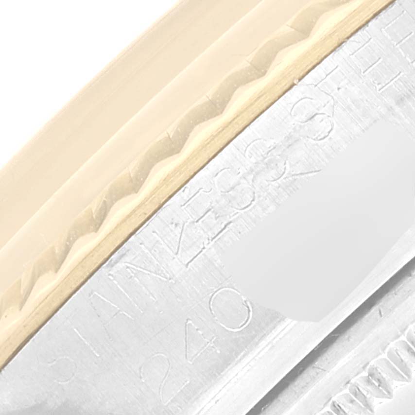 This image shows a close-up of the side of a Rolex Vintage Collection 1601 Men's Steel and Gold (two tone) Blue Dial 1601 Men's Steel and Gold (two tone) Blue Dial watch, highlighting its stainless steel bezel and engraved text.