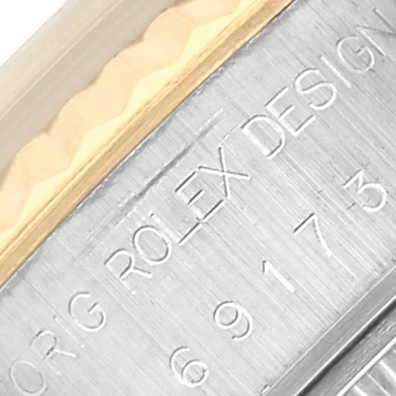 The image shows a close-up of the side of a Rolex Datejust 69173 Women's Steel and Gold (two tone) Champagne Dial 69173 Women's Steel and Gold (two tone) Champagne Dial watch case, highlighting the engraved serial number and brand name.