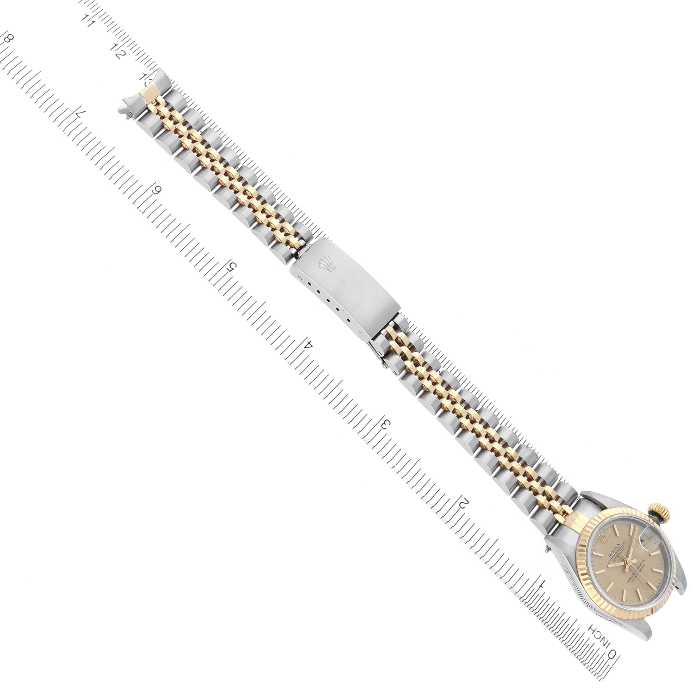 The image shows a Rolex Datejust 69173 Women's Steel and Gold (two tone) Champagne Dial 69173 Women's Steel and Gold (two tone) Champagne Dial watch from a top-down angle, highlighting the bracelet, clasp, and dial alongside a ruler for scale.
