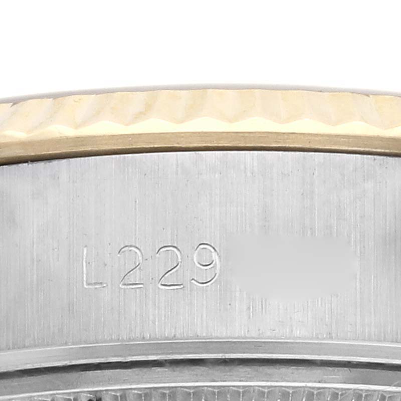 The image shows a close-up of the side of a Rolex Datejust 69173 Women's Steel and Gold (two tone) Champagne Dial 69173 Women's Steel and Gold (two tone) Champagne Dial, focusing on the case and bezel with engraved serial numbers.