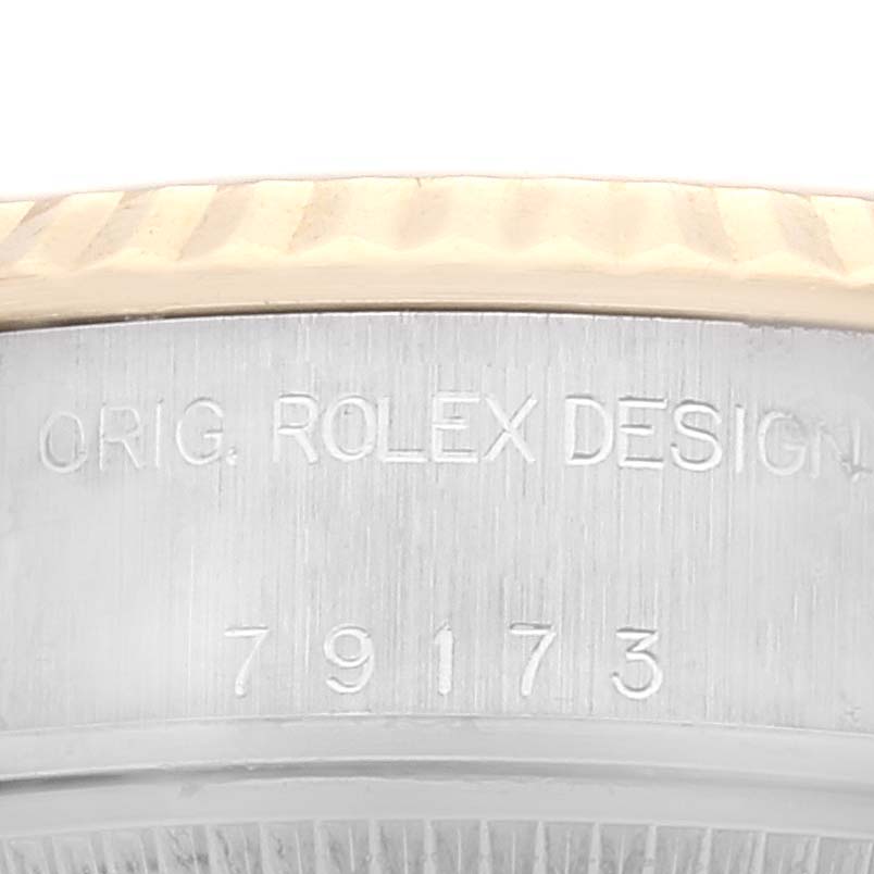 The image shows a close-up of the side of a Rolex Datejust 79173 Women's Steel and Gold (two tone) Champagne Dial 79173 Women's Steel and Gold (two tone) Champagne Dial watch, featuring the bezel and engraved design details.