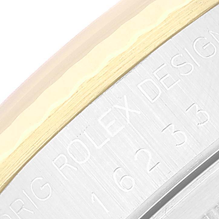The image shows a close-up angle of the bezel and engraved serial number on a Rolex Datejust 16233 Men's Steel and Gold (two tone) Beige Dial 16233 Men's Steel and Gold (two tone) Beige Dial model.