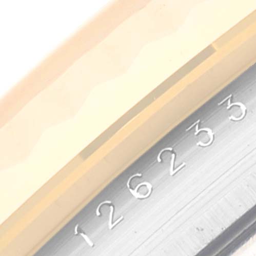 This close-up image shows a partial view of the face and serial number of a Rolex Datejust 126233 Men's Steel and Gold (two tone) Silver Dial 126233 Men's Steel and Gold (two tone) Silver Dial watch.