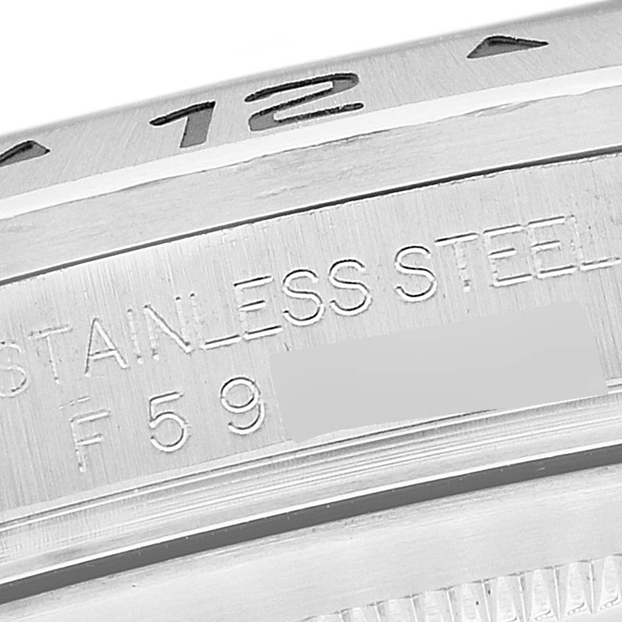 This is a close-up of the Rolex Explorer 16570T Men
s Stainless Steel Black Dial 16570T Men
s Stainless Steel Black Dial watch, showing the "STAINLESS STEEL" engraving and part of the bezel with the number "12".