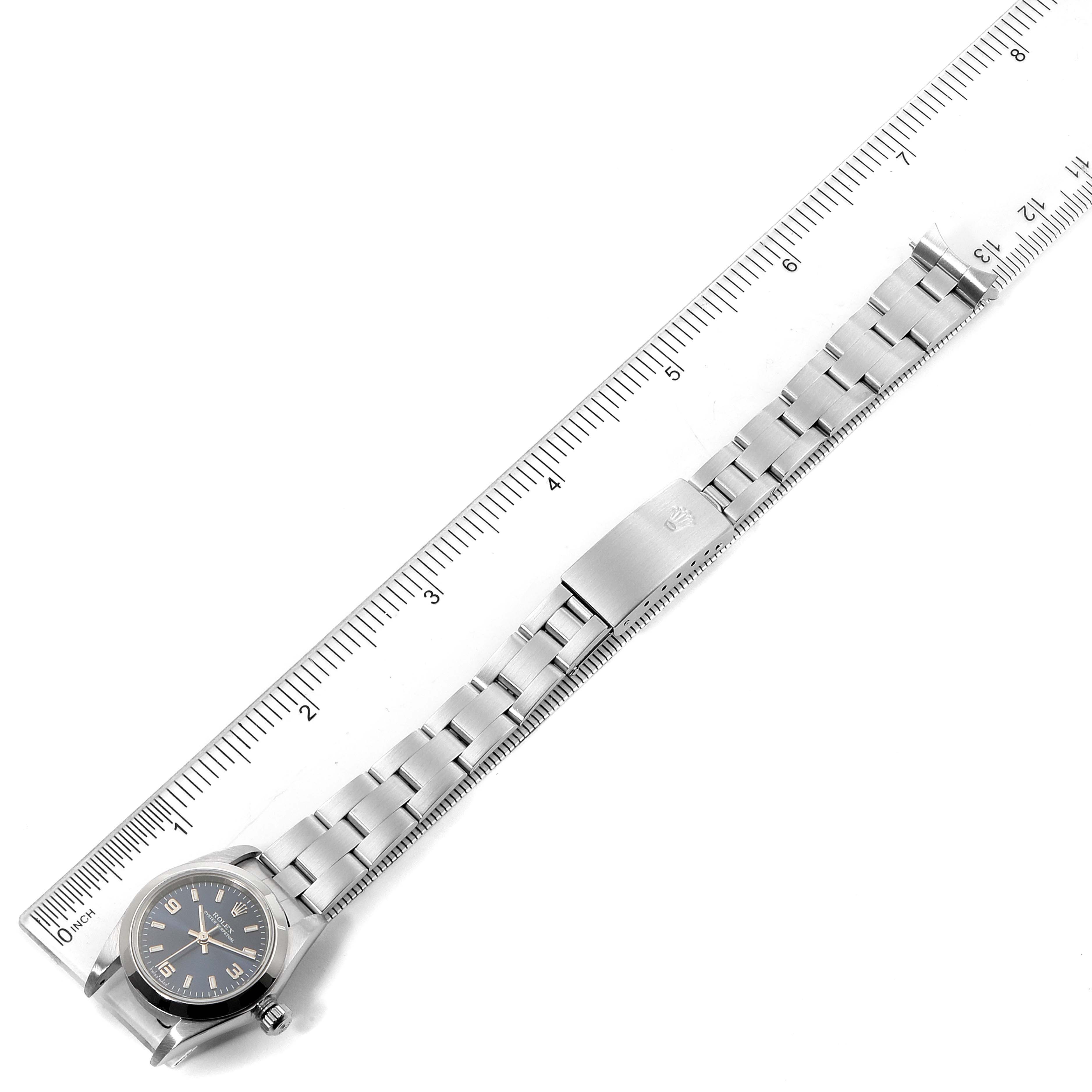 The image shows a Rolex Oyster Perpetual 76080 Women
s Stainless Steel Blue Dial 76080 Women
s Stainless Steel Blue Dial watch laid flat with a ruler for scale, capturing the entire watch and bracelet.