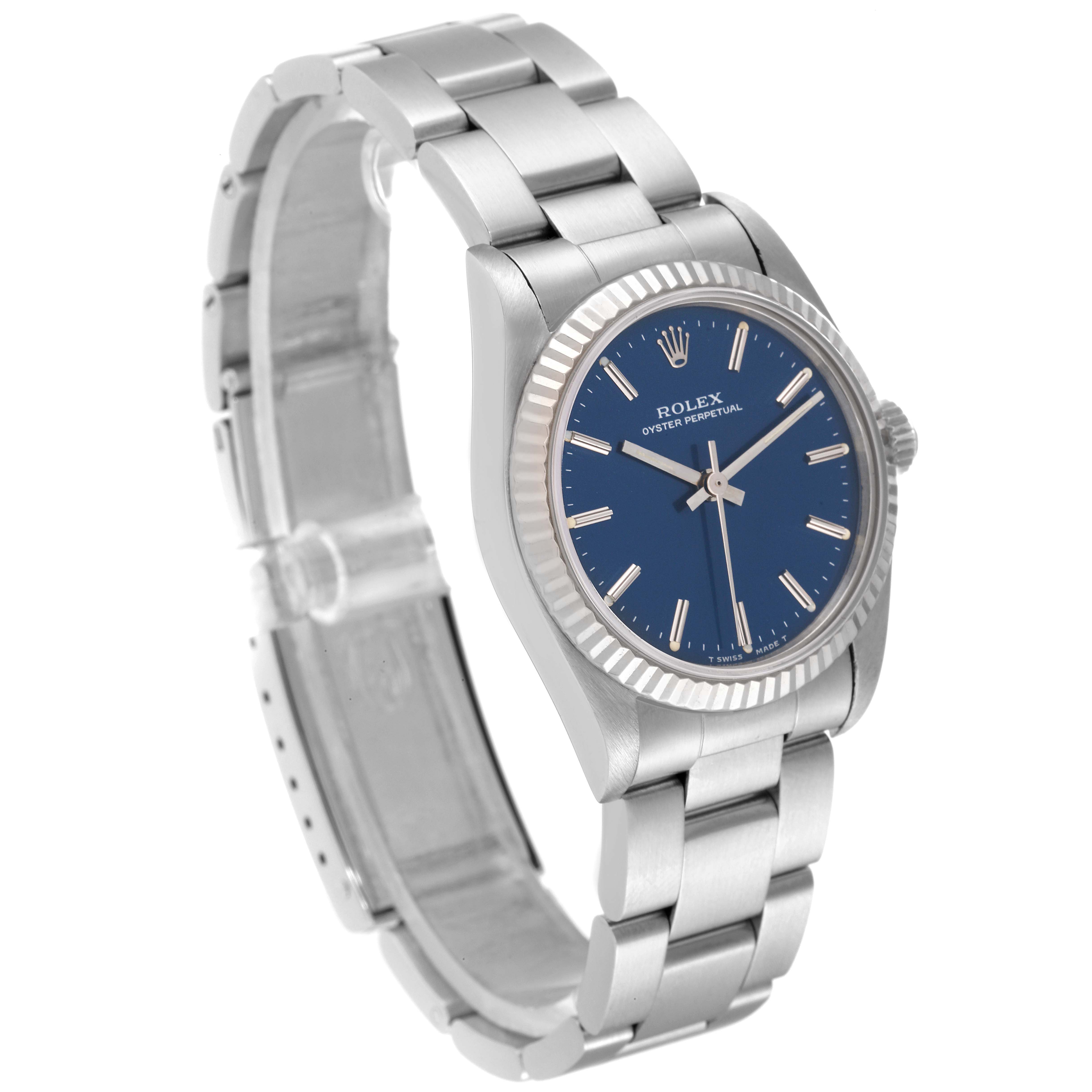 The image shows a Rolex Oyster Perpetual Mid-Size model at a slightly angled side view, highlighting its blue dial and stainless steel bracelet.