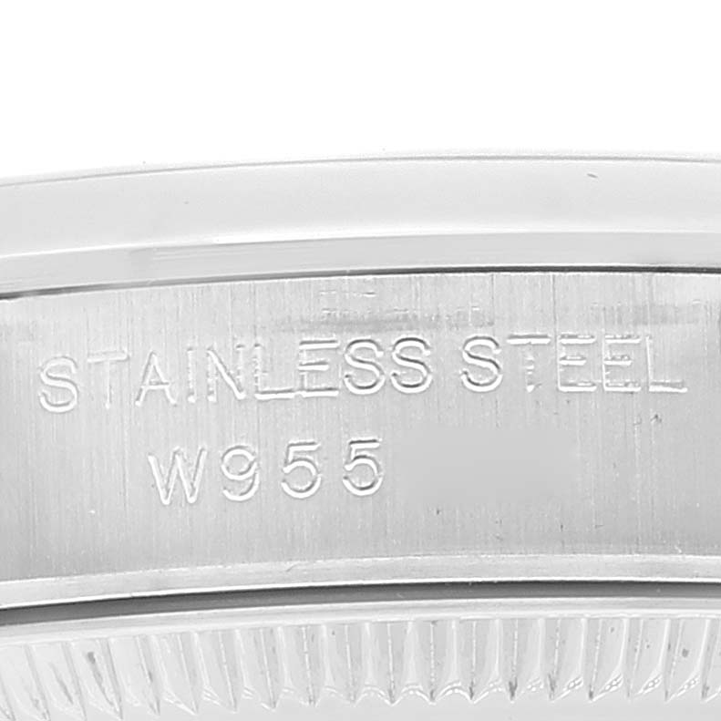 This close-up image shows a portion of the stainless steel back case of a Rolex Oyster Perpetual 67180 Women
s Stainless Steel Pink Dial 67180 Women
s Stainless Steel Pink Dial watch, highlighting the engraved text "STAINLESS STEEL" and "W955."