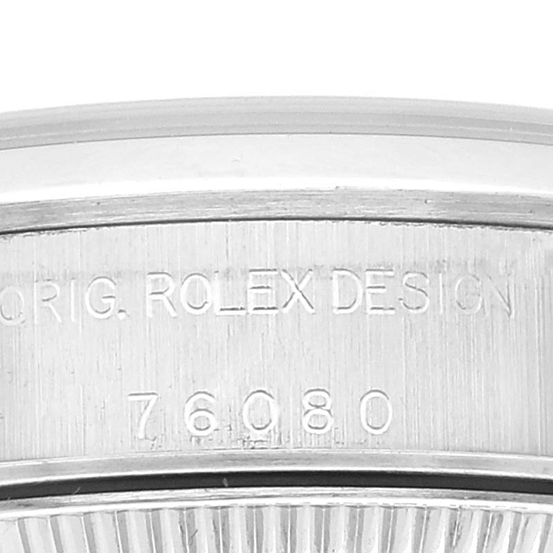 This image shows a close-up of the case back of the Rolex Oyster Perpetual 76080 Women
s Stainless Steel Pink Dial 76080 Women
s Stainless Steel Pink Dial watch, highlighting the engraved text and model number.