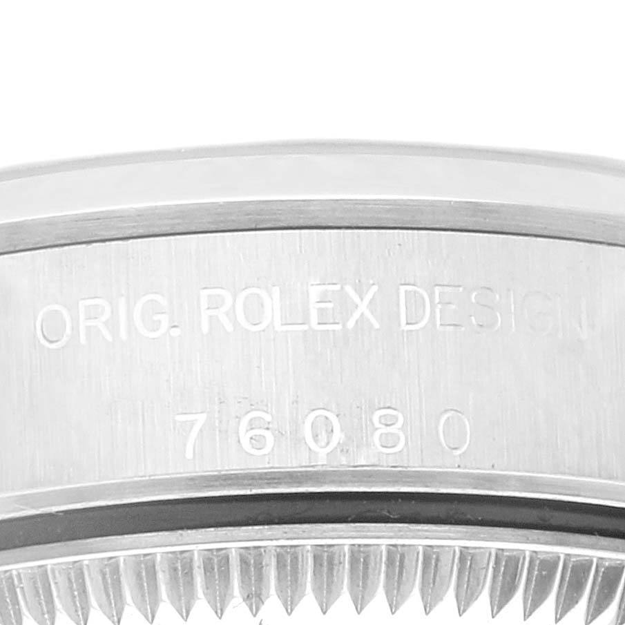 This image shows a close-up of the side of a Rolex Oyster Perpetual 76080 Women
s Stainless Steel Pink Dial 76080 Women
s Stainless Steel Pink Dial watch, specifically displaying the engraved design reference number.