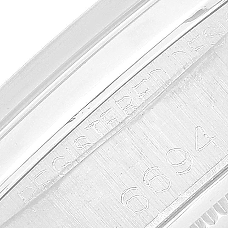 The image shows a close-up of the engraved serial number and reference details on the side of the Rolex Vintage Collection 6694 Men's Stainless Steel Silver Dial 6694 Men's Stainless Steel Silver Dial watch case.