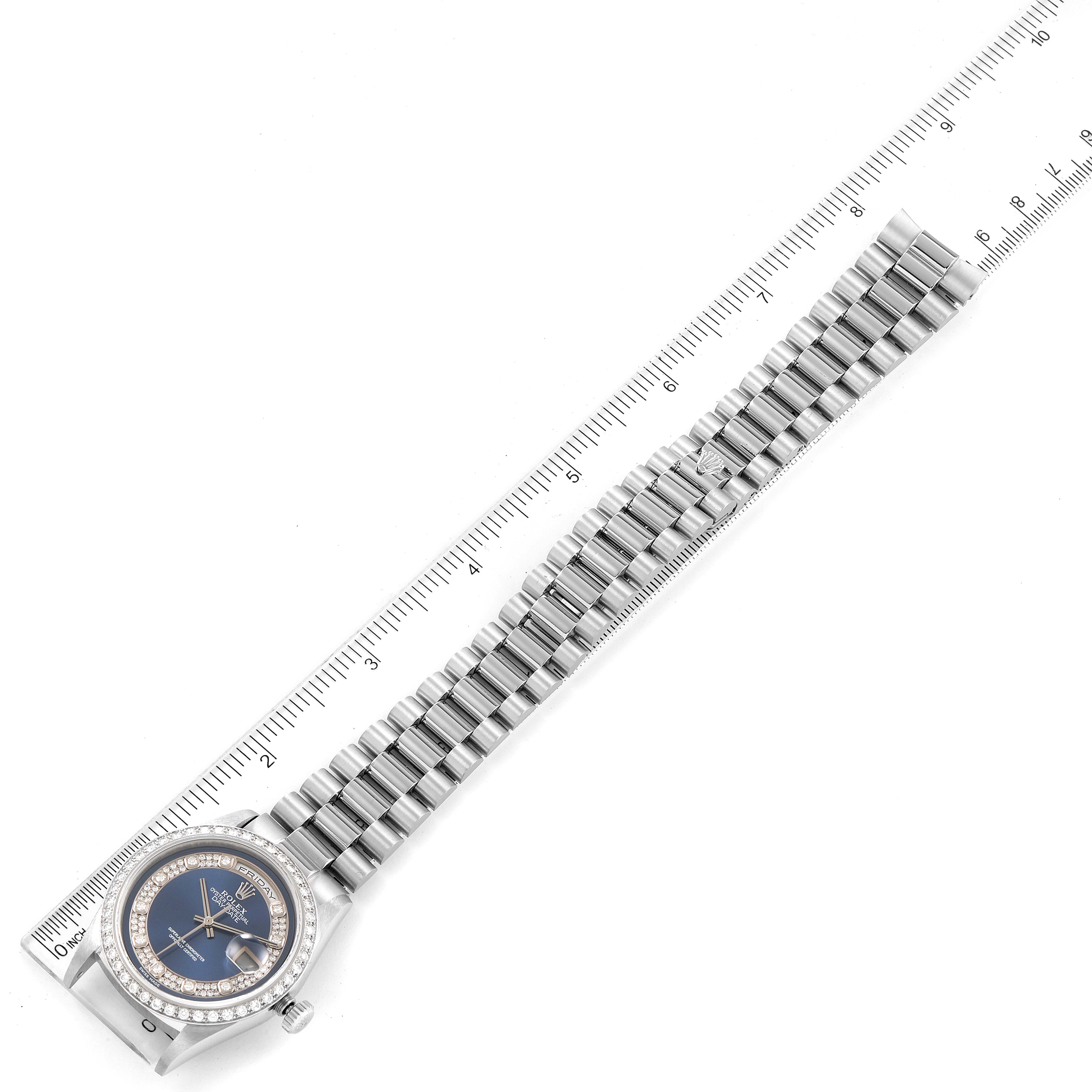 This image shows a top view of a Rolex President 18346 Men's Platinum Blue Dial 18346 Men's Platinum Blue Dial model watch with its bracelet aligned alongside a ruler.