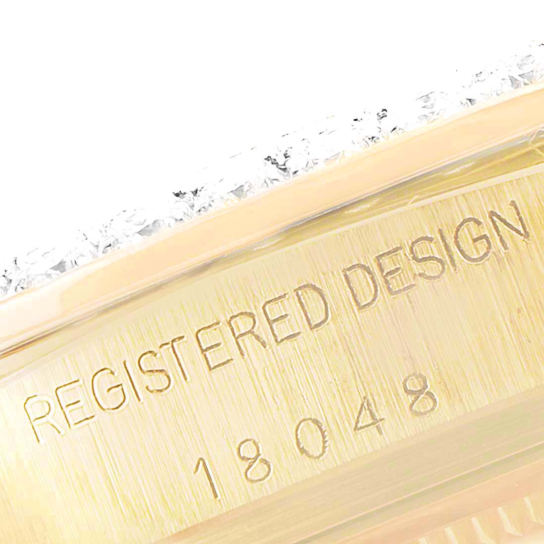 This close-up of a Rolex President 18048 Men
s Yellow Gold Champagne Dial 18048 Men
s Yellow Gold Champagne Dial watch shows part of the bezel and the engraved model number (18048) on the side.