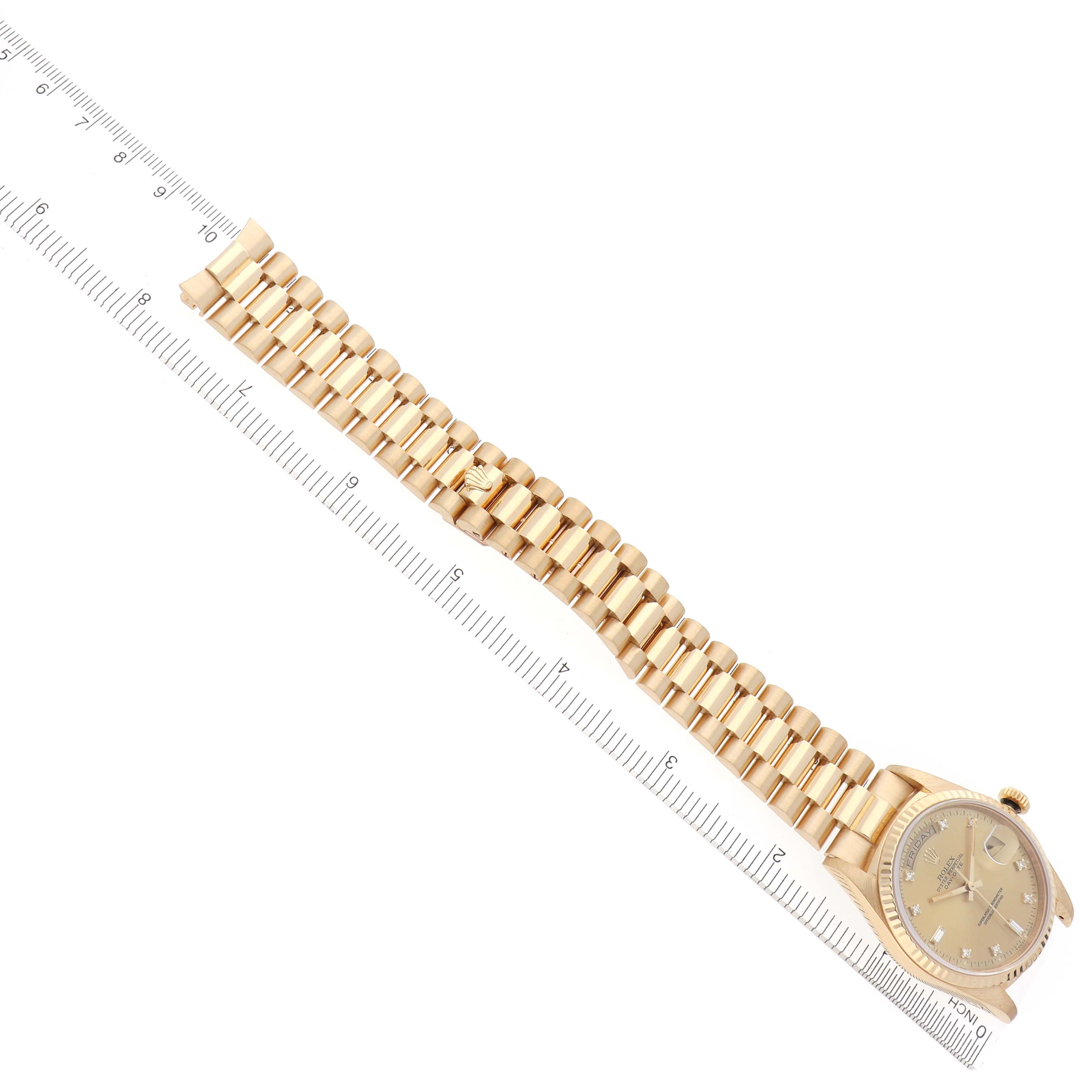 The Rolex President 18238 Men
s Yellow Gold Champagne Dial 18238 Men
s Yellow Gold Champagne Dial model watch is shown from an overhead angle, displaying the face and entire gold bracelet alongside a ruler for scale.