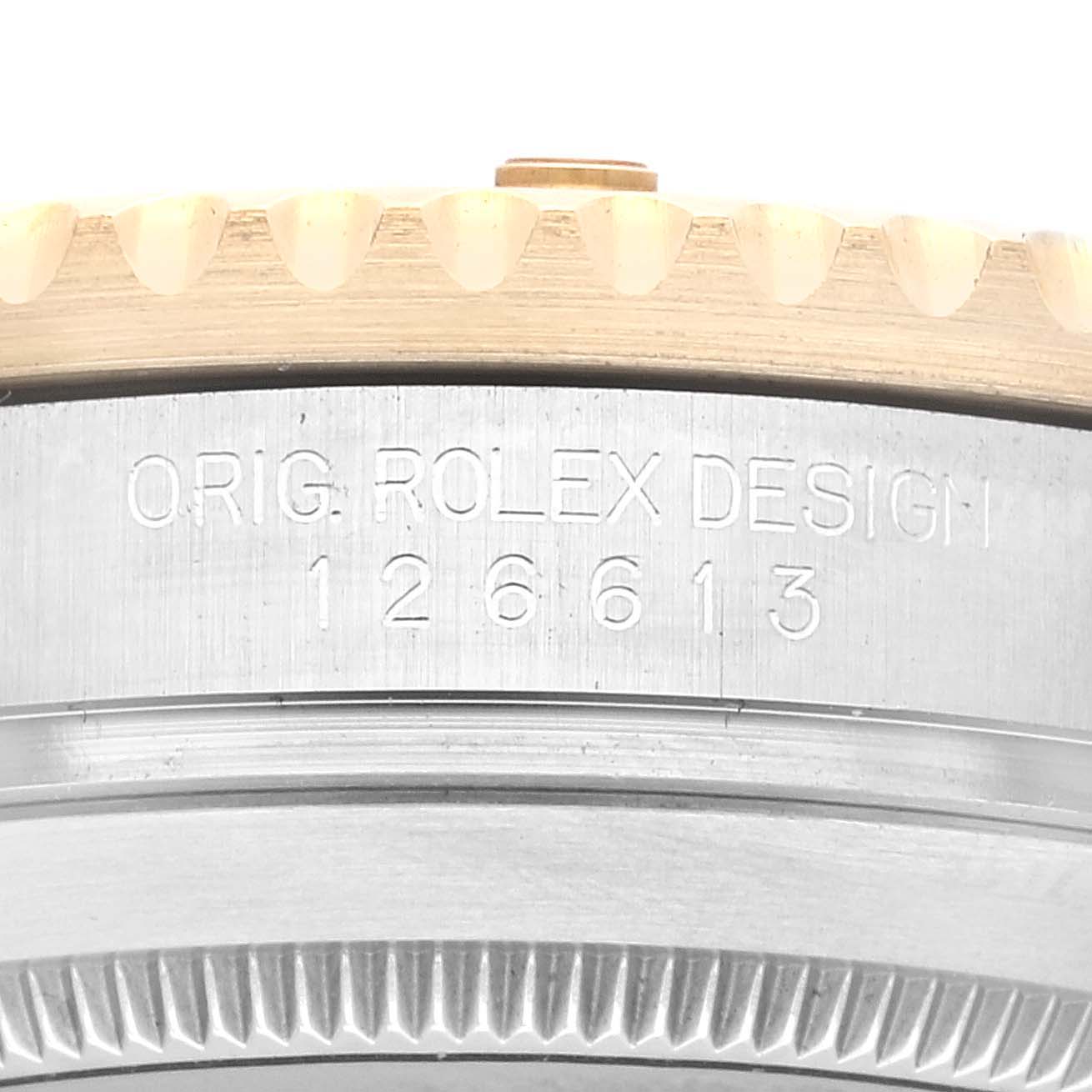 Close-up of the engraved side of a Rolex Submariner 126613LN Men's Steel and Gold (two tone) Black Dial 126613LN Men's Steel and Gold (two tone) Black Dial watch case, showing "ORIG. ROLEX DESIGN 126613."