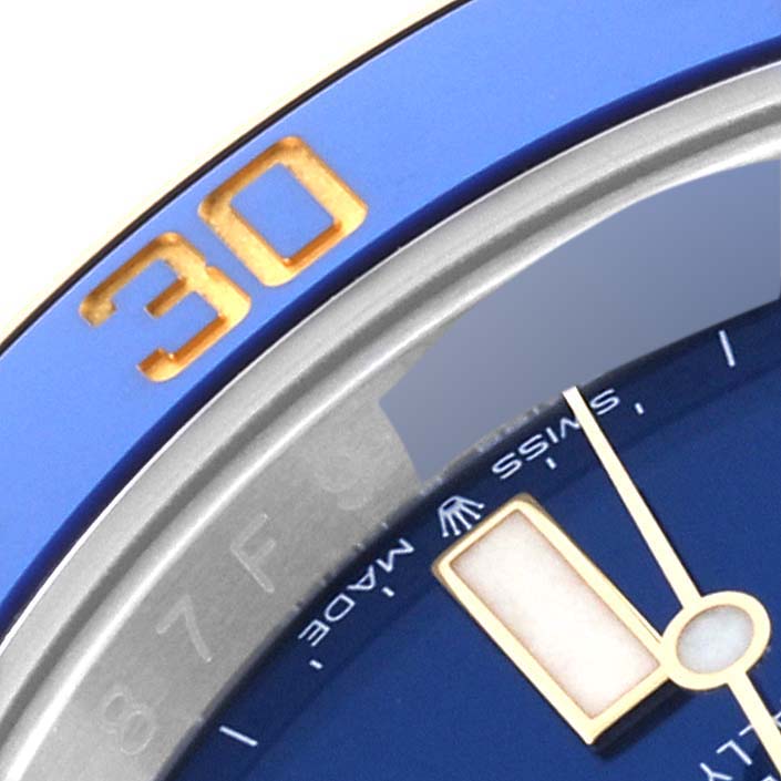 This close-up image of a Rolex Submariner 126613LB Men
s Steel and Gold (two tone) Blue Dial 126613LB Men
s Steel and Gold (two tone) Blue Dial watch shows a portion of its blue dial, minute hand, and part of the bezel with the number "30."