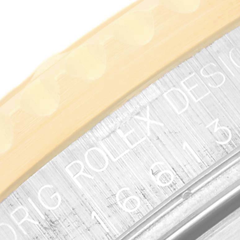 This close-up image shows part of the bezel and engraved details on the casing of the Rolex Submariner 16613 Men
s Steel and Gold (two tone) Black Dial 16613 Men
s Steel and Gold (two tone) Black Dial watch.