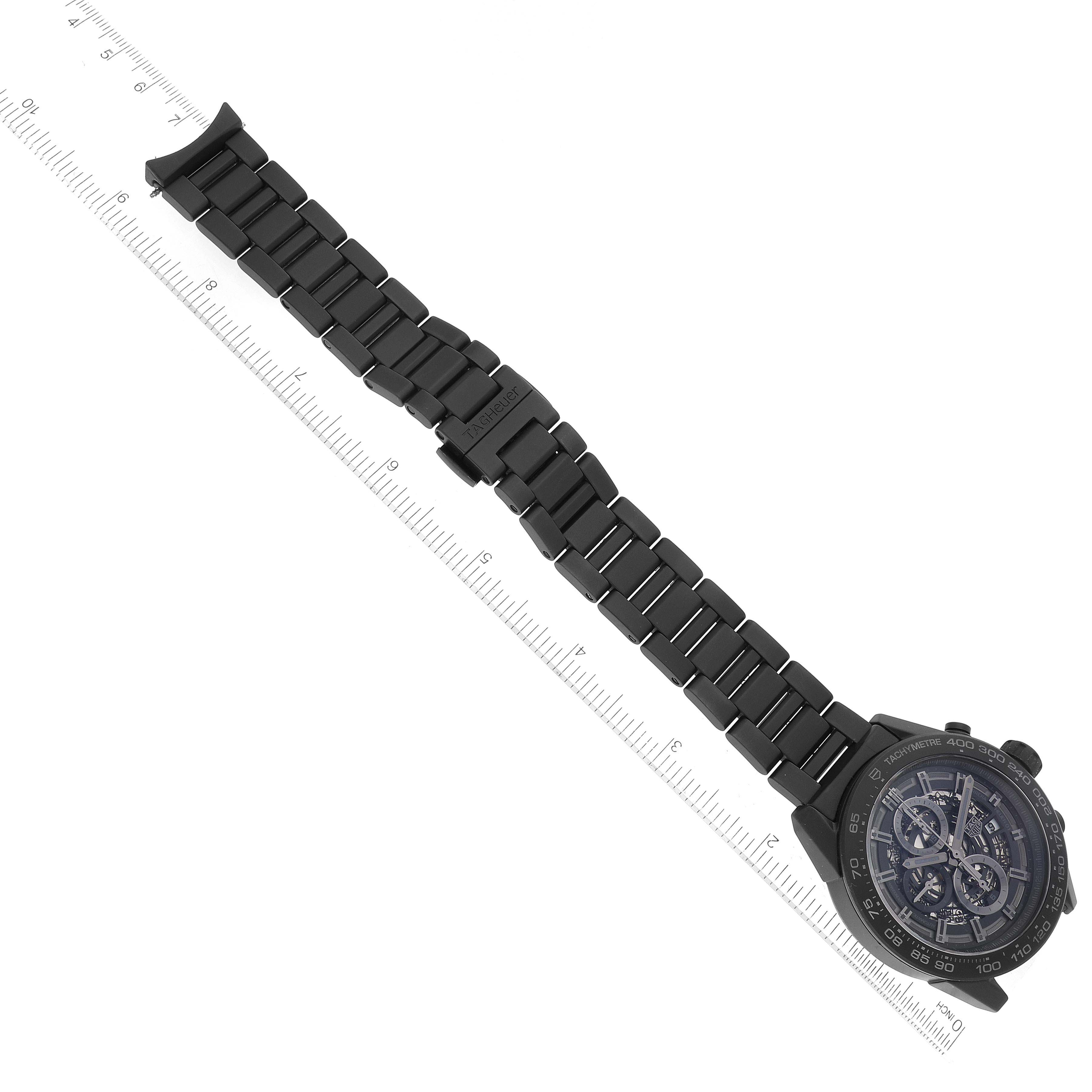 The image shows a Tag Heuer Carrera CAR2A91.BH0742 Men's Ceramic Transparent Dial CAR2A91.BH0742 Men's Ceramic Transparent Dial watch at a slight angle, featuring its face and full metal link bracelet along a ruler.