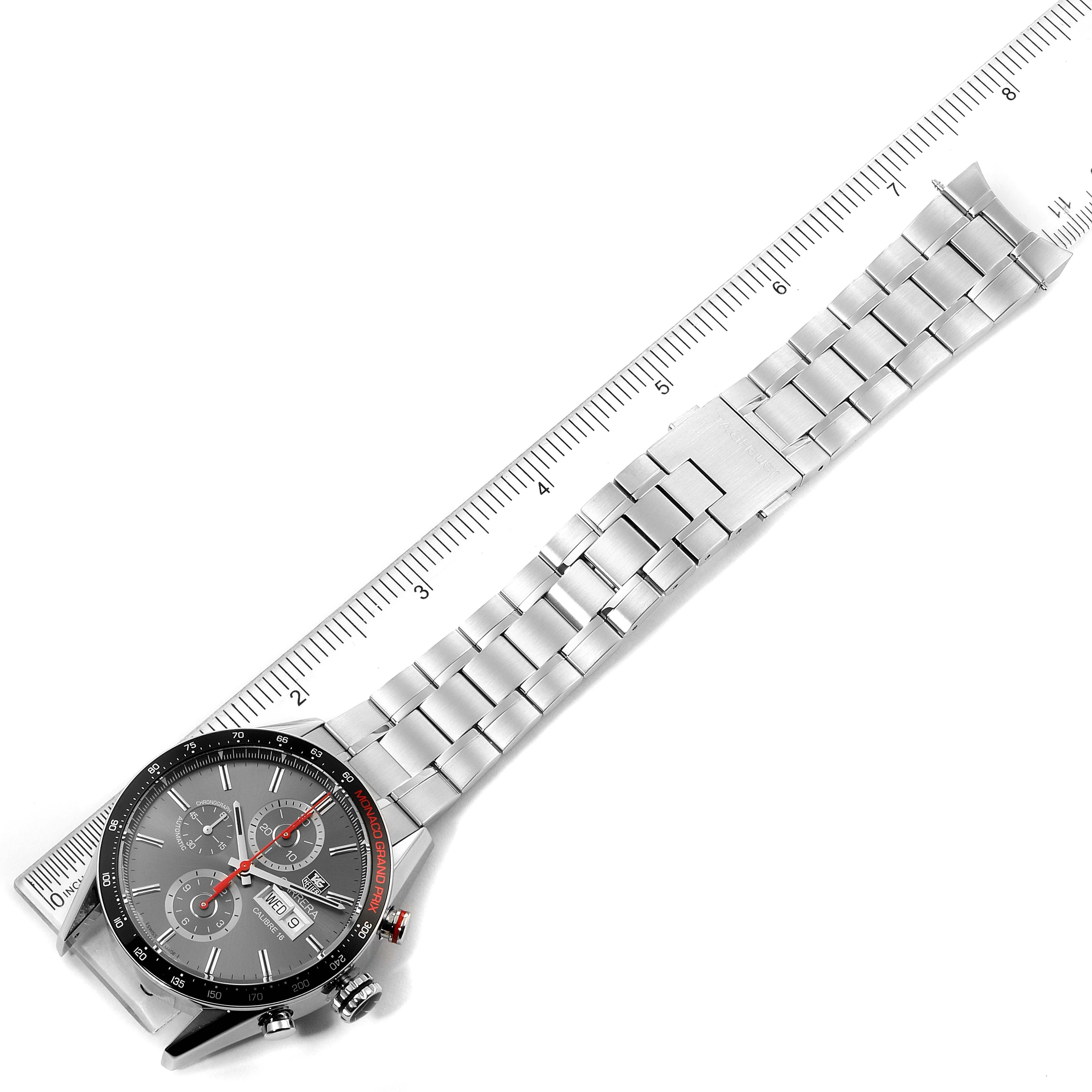 The image displays a Tag Heuer Monaco CV2A1M.FT6033 Men's Stainless Steel Black Dial CV2A1M.FT6033 Men's Stainless Steel Black Dial watch lying flat, showing its face and metal bracelet alongside a ruler for scale.