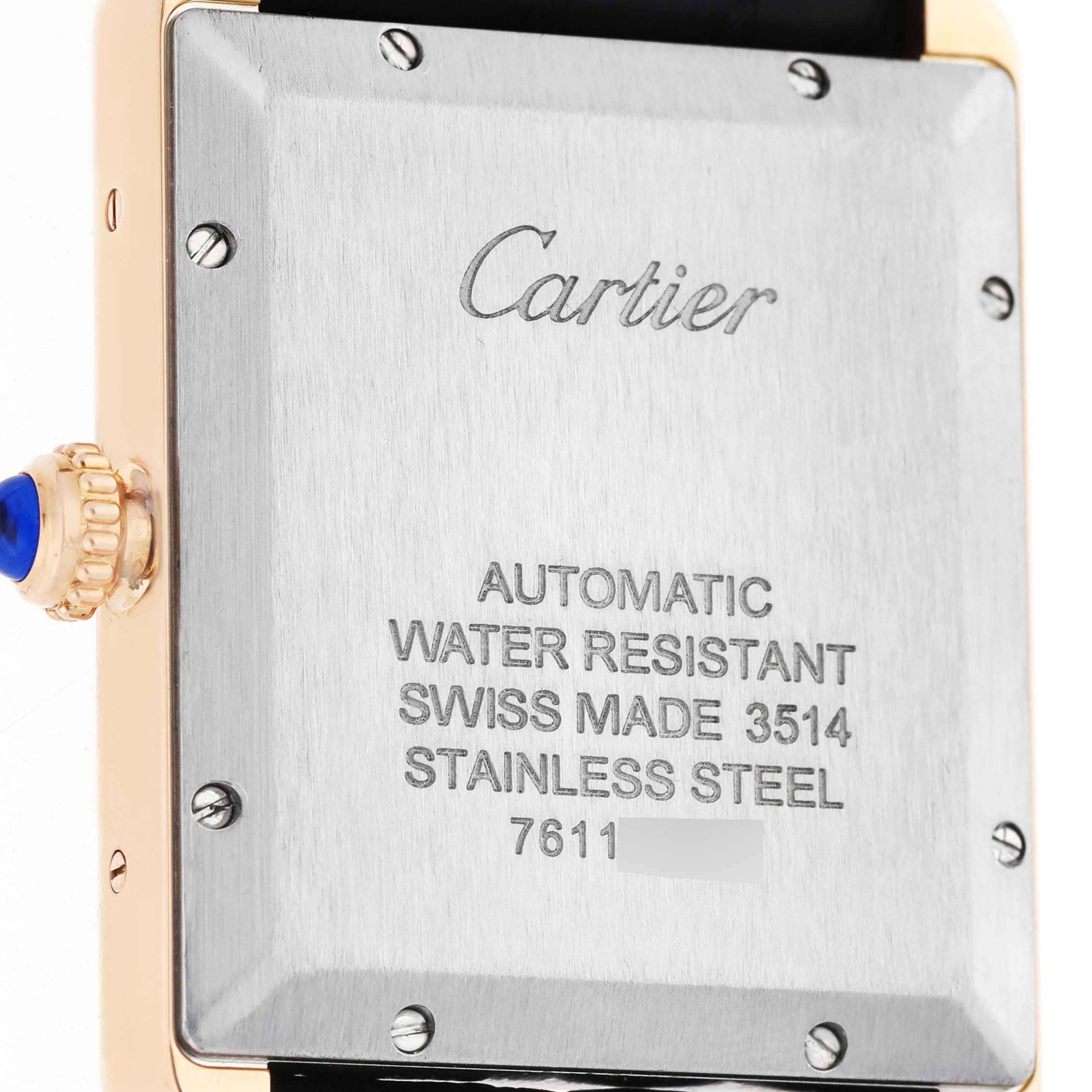 The image shows the back case and side crown of a Cartier Tank Solo W5200026 Men's Rose Gold Silver Dial watch, highlighting its engraved details and a blue cabochon on the crown.