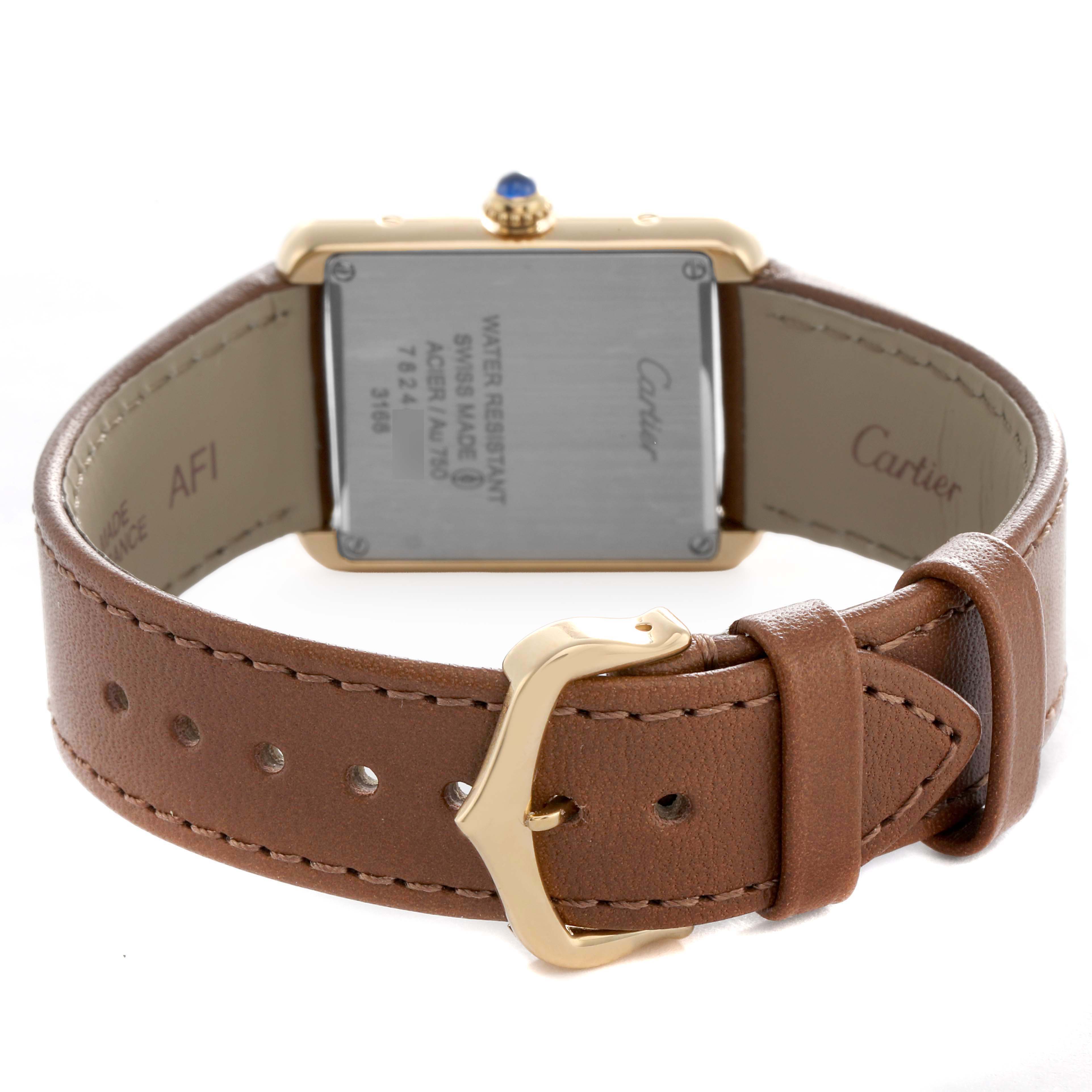 The image shows the back of a Cartier Tank Solo W5200002 Women's Yellow Gold Silver Dial watch, featuring its caseback and brown leather strap with a gold buckle.