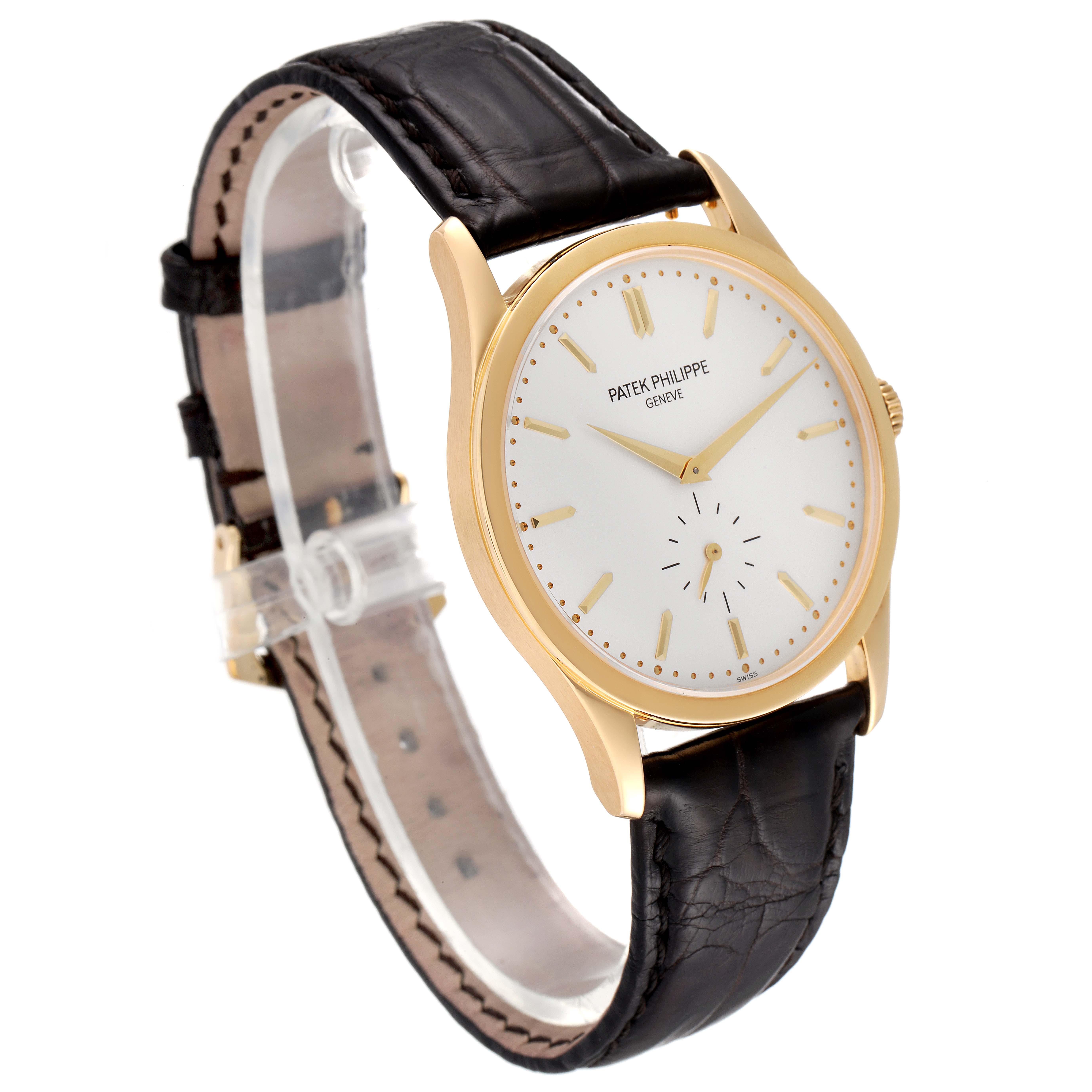 The image shows a Patek Philippe Calatrava 5196J Men's Yellow Gold Silver Dial 5196J Men's Yellow Gold Silver Dial watch at a three-quarter angle, highlighting the gold case, white dial, and black leather strap.