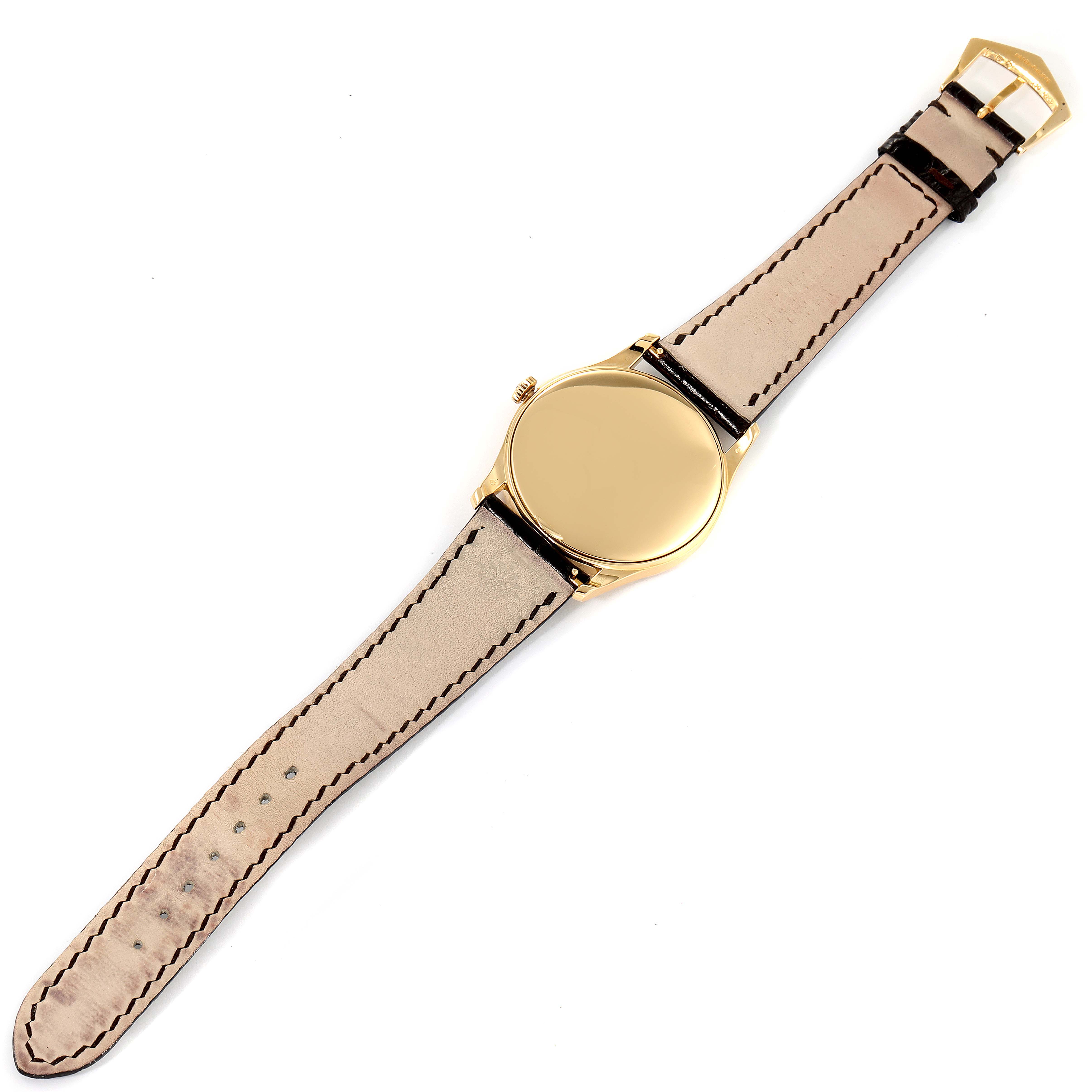 The image shows a Patek Philippe Calatrava 5196J Men's Yellow Gold Silver Dial 5196J Men's Yellow Gold Silver Dial watch from a top-down angle, highlighting the case back and leather strap.