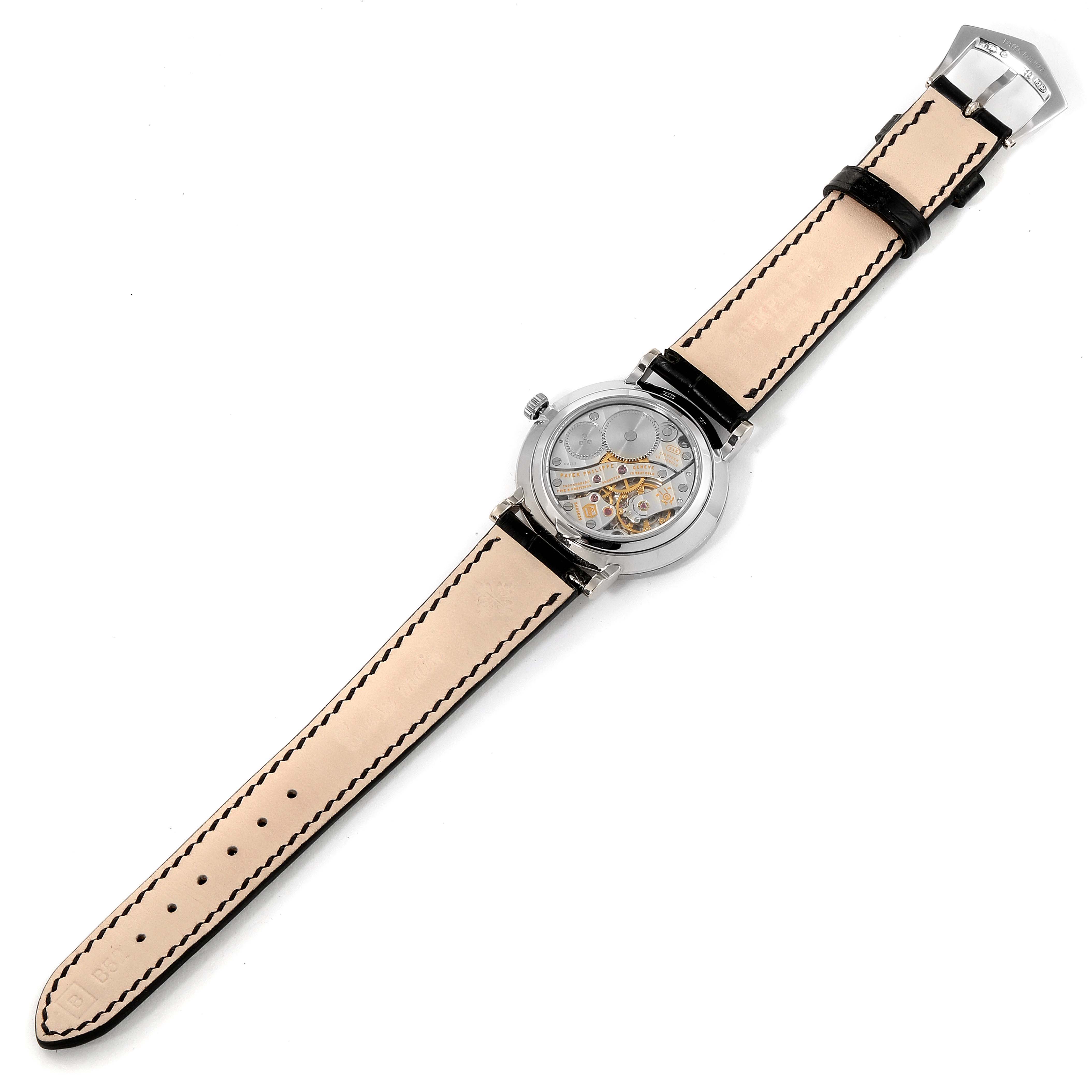 The image shows a Patek Philippe Calatrava 7119G Women's White Gold White Dial 7119G Women's White Gold White Dial watch from a top view, highlighting its full open strap and transparent case back.