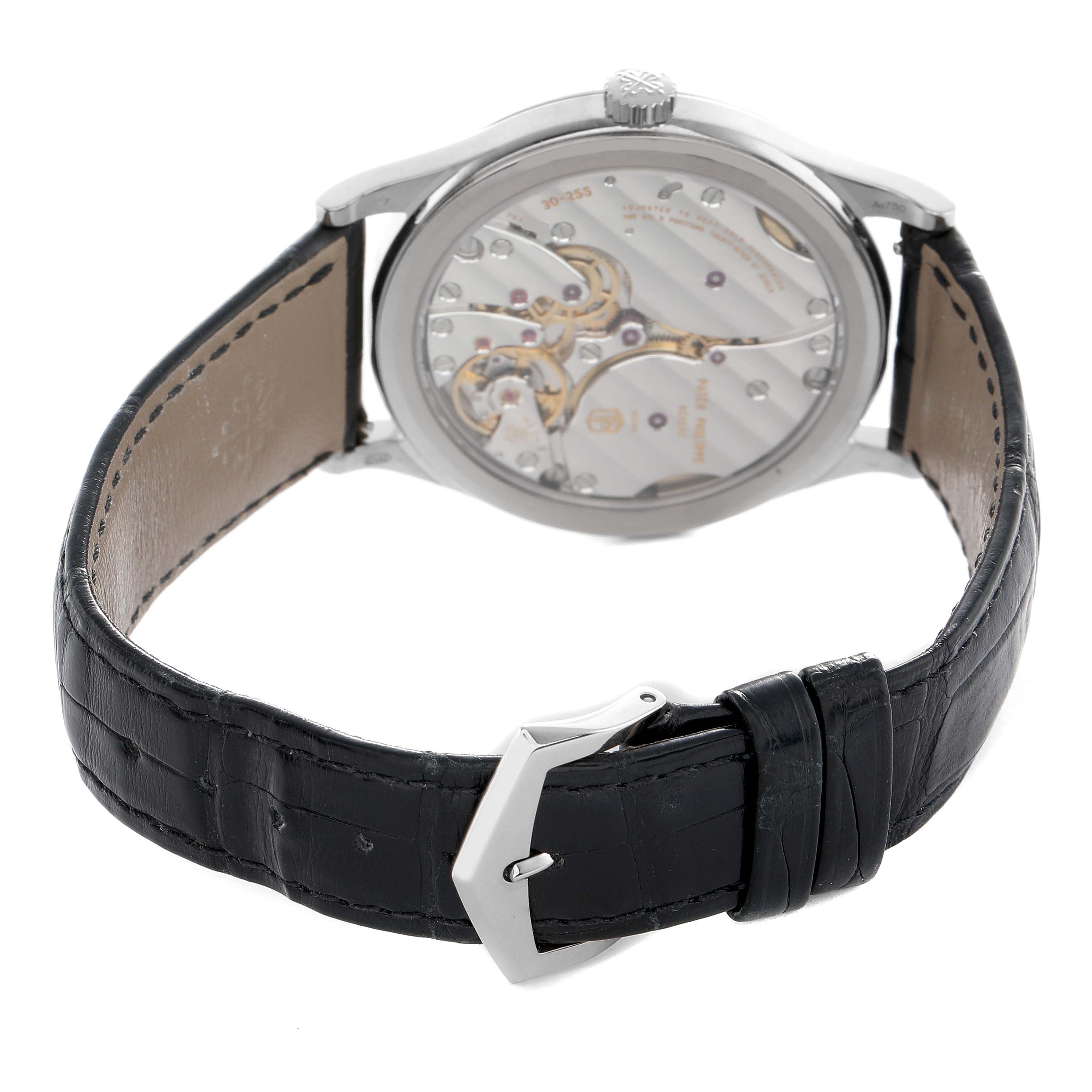 The watch is a Patek Philippe Calatrava 6119G-001 Men's White Gold Grey Dial, shown from the back displaying its movement and a black leather strap with buckle.