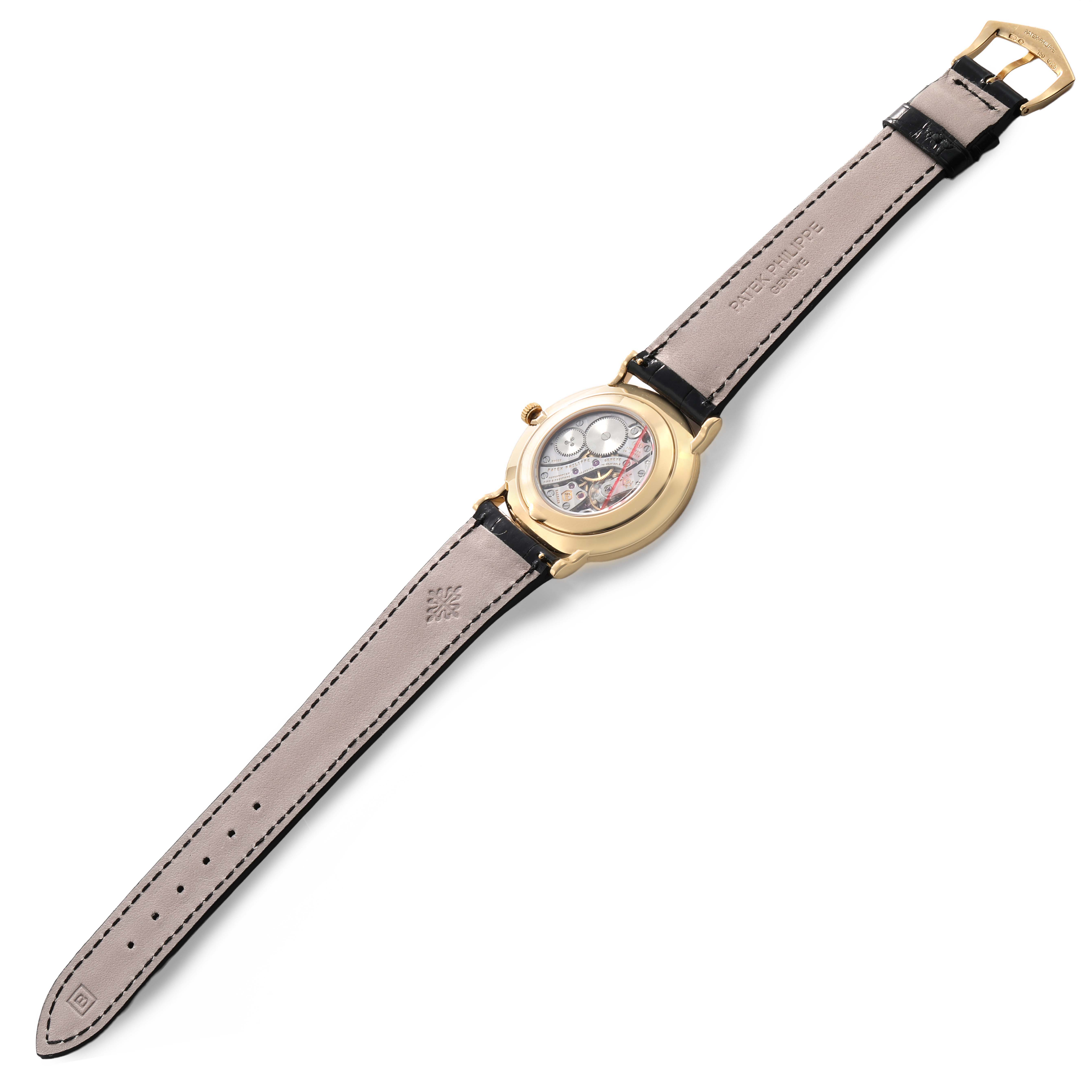 The Patek Philippe Calatrava 5119J-001 Men's Yellow Gold White Dial watch is shown at a slight angle from the back, displaying the movement and full leather strap.