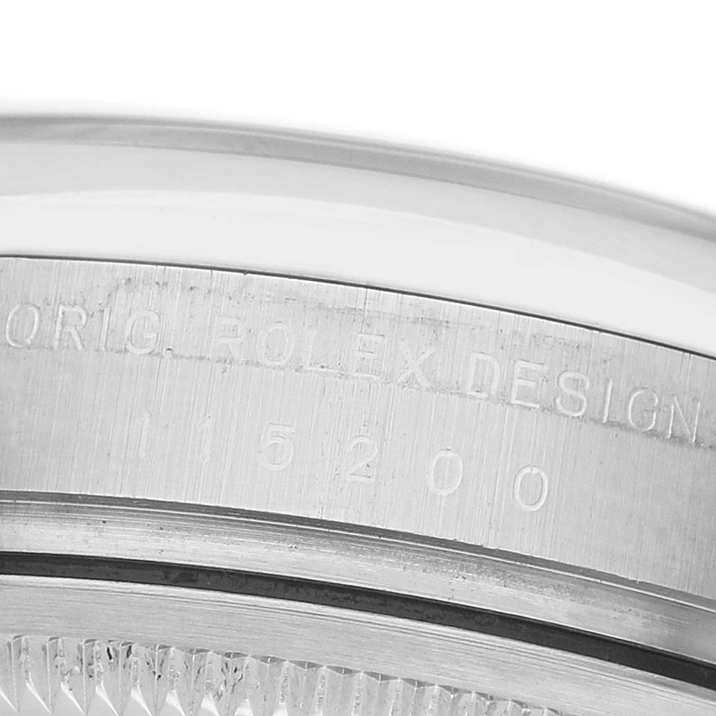 The image shows a close-up of the bezel and engraved model number "15200" of a Rolex Date 115200 Men's Stainless Steel White Dial watch.